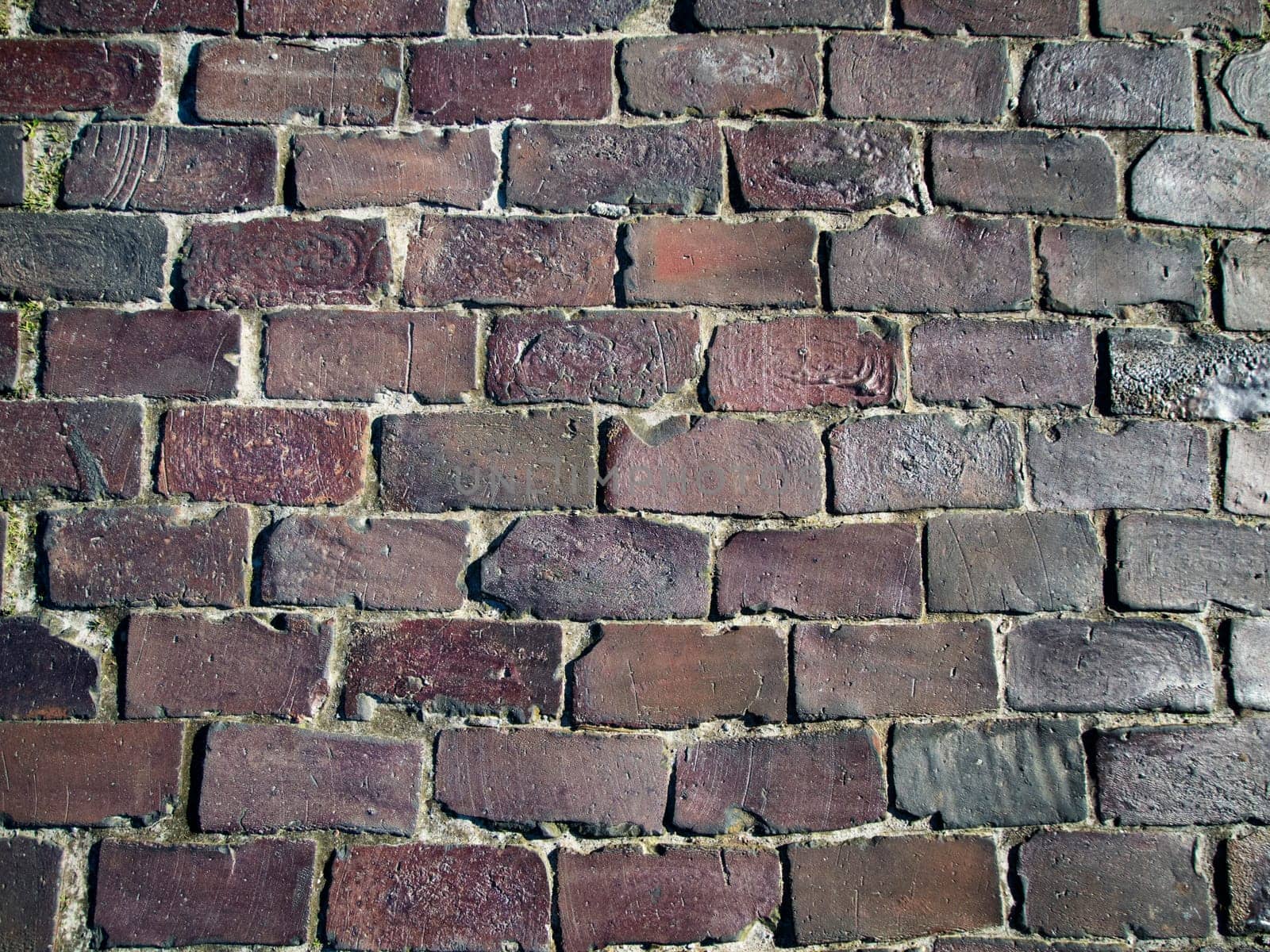 Full-format frontal view of a brick wall made of fired bricks.