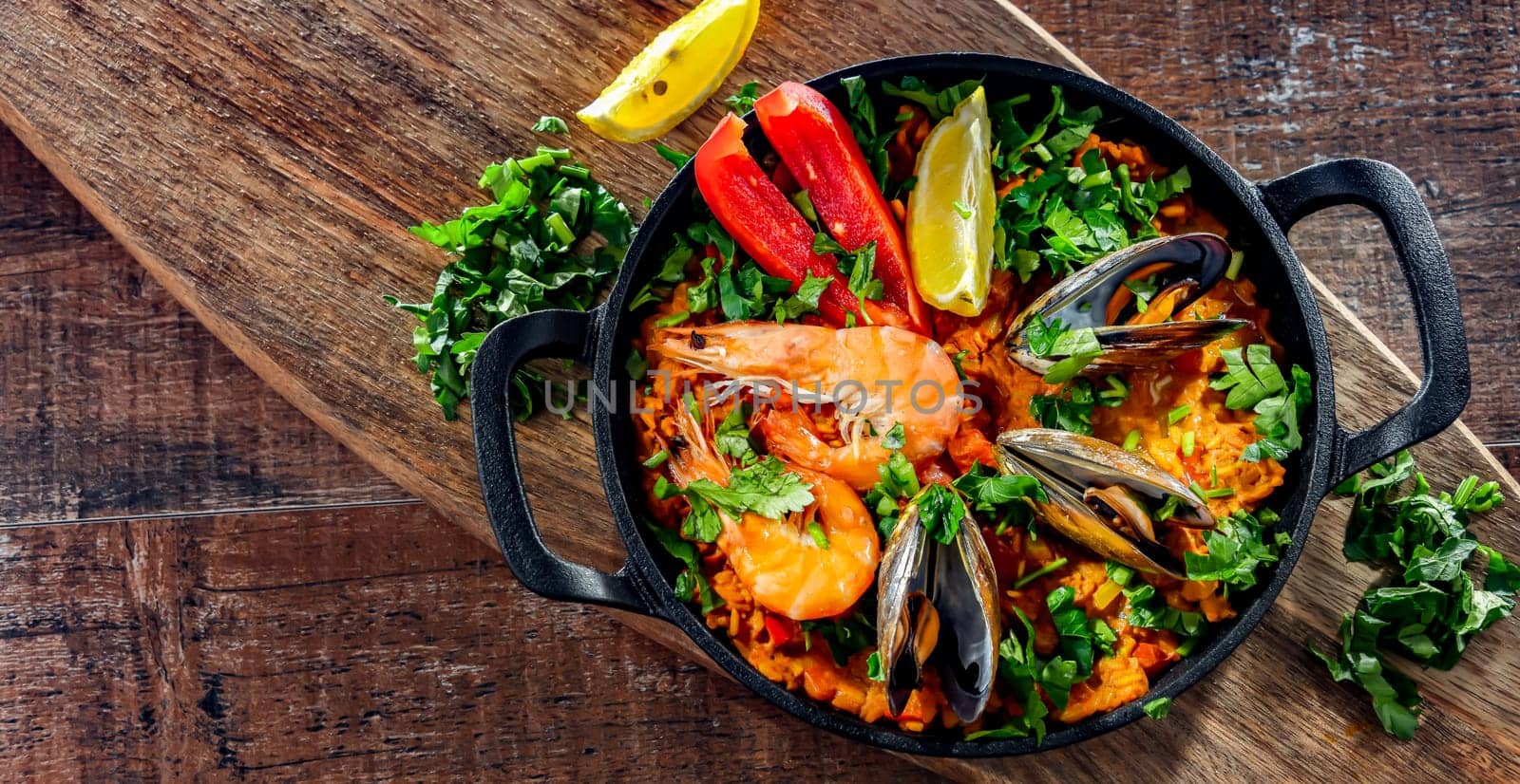 Seafood paella served in a cast iron pan.