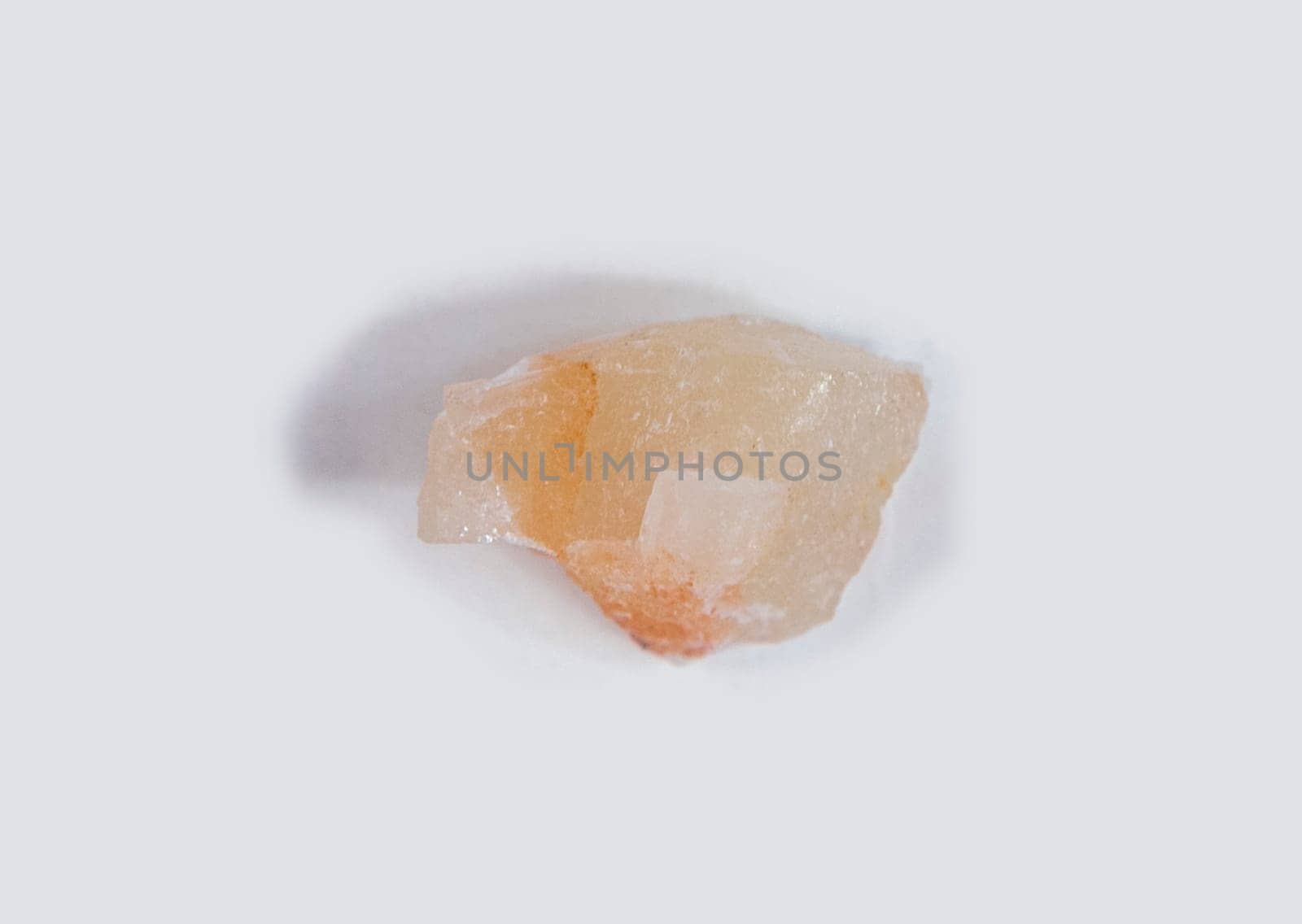 Amber calcite fragment, believed to have beneficial health properties. Isolated over white fabric cloth