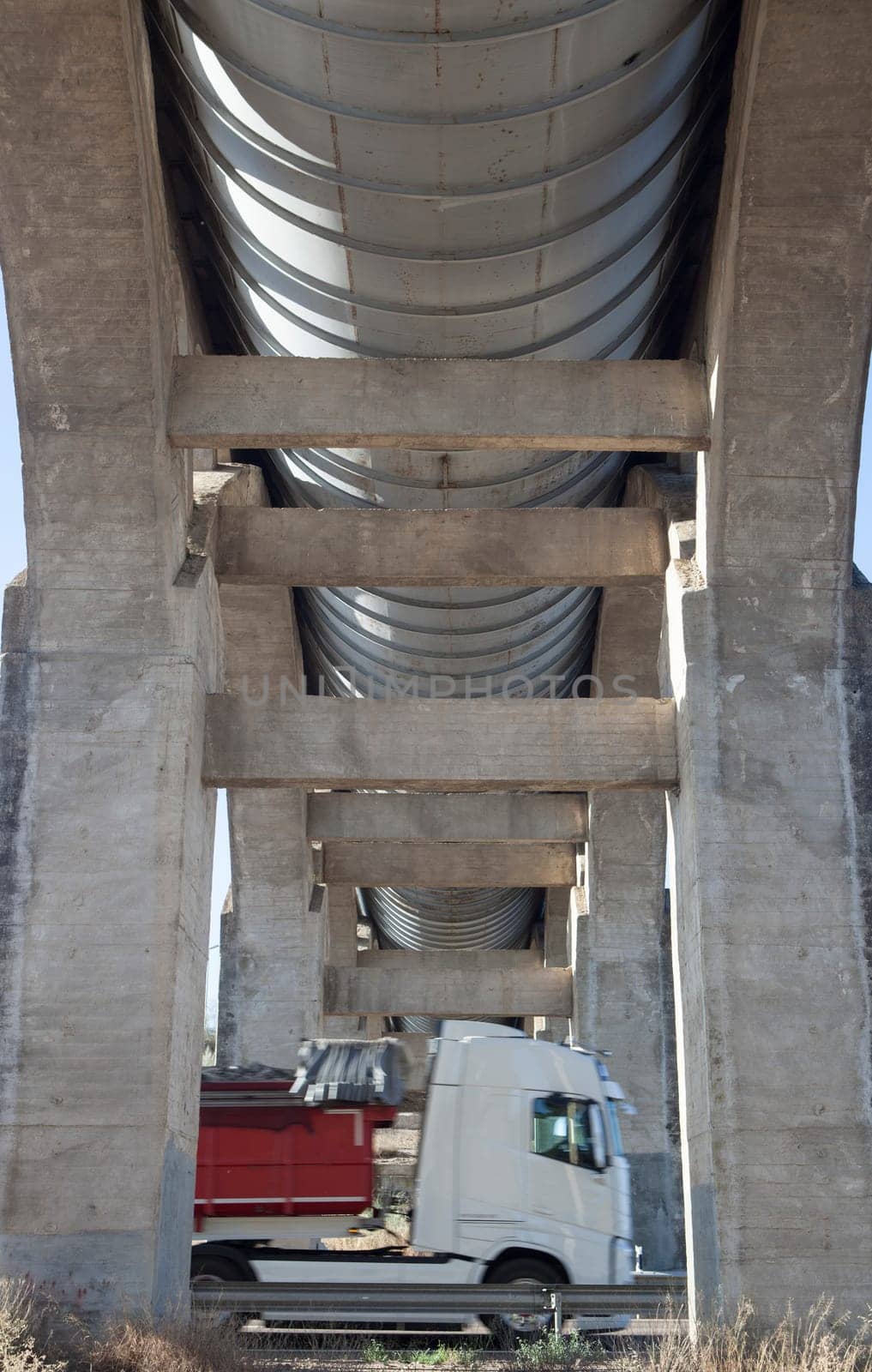Truck crossing under Acedera Aqueduct through N430 National Road. Motion bluerred