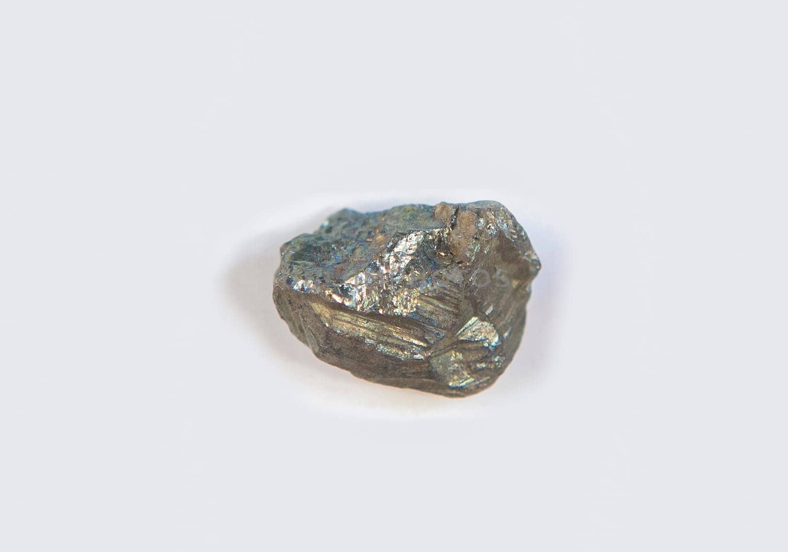 Fragment of pyrite mineral. Isolated over white fabric cloth