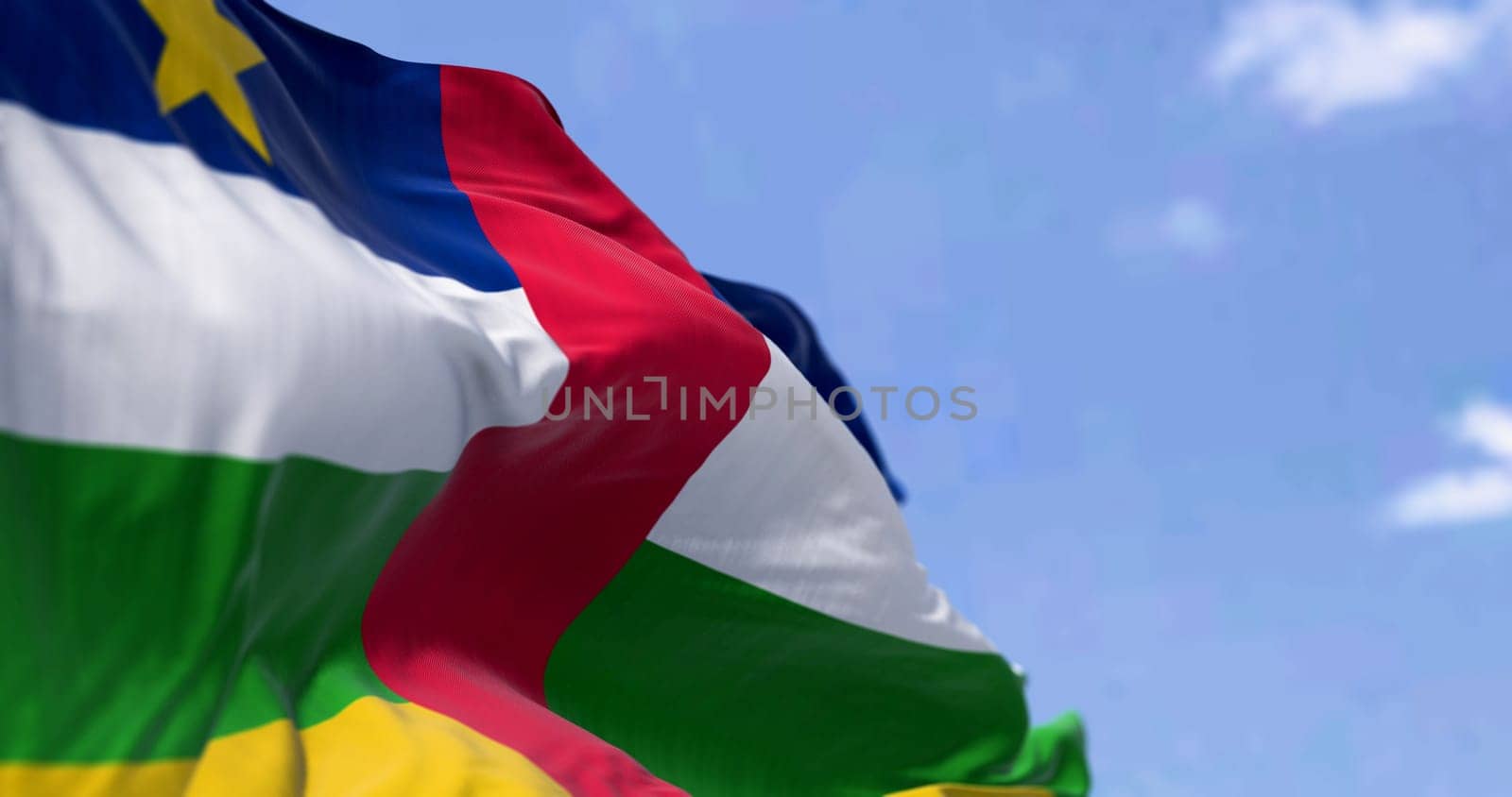 National flag of Central African Republic waving on a clear day. Blue, white, green, and yellow stripes with a red stripe in the middle and a yellow star in the canton. 3d illustration render. Fluttering fabric