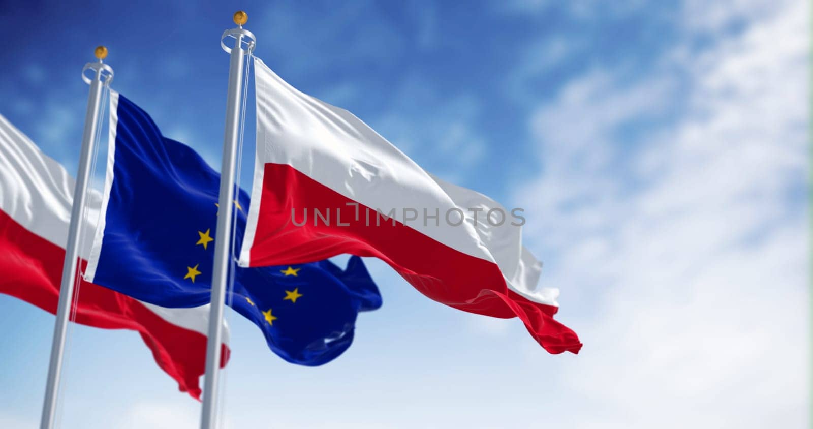Flags of Poland and the European Union waving in the wind on a clear day. Poland became a member of the EU in may 2004. 3d illustration render. Fluttering fabric. Selective focus