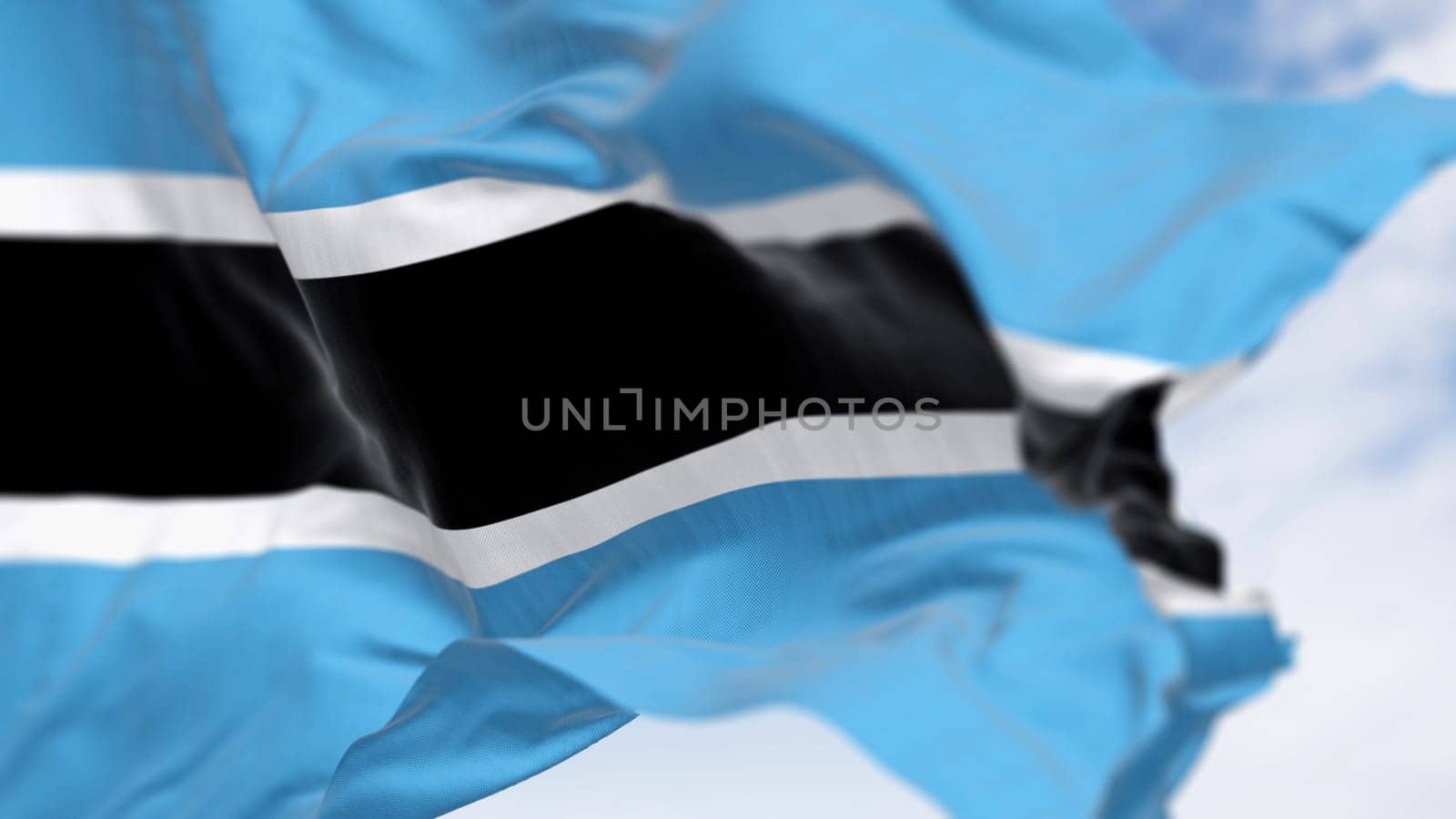Close-up of Botswana national flag waving on a clear day. Light blue field with a horizontal black and white stripe in the center. 3d illustration render. Fluttering fabric. Selective focus