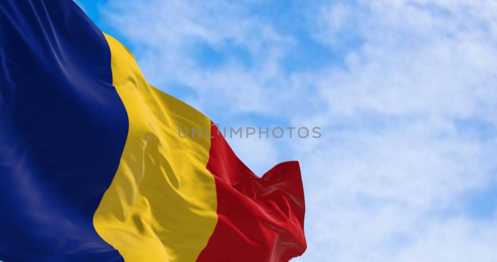 National flag of Romania waving in the wind on a clear day. Three vertical stripes of blue, yellow, and red. 3d illustration render. Fluttering fabric. Selective focus
