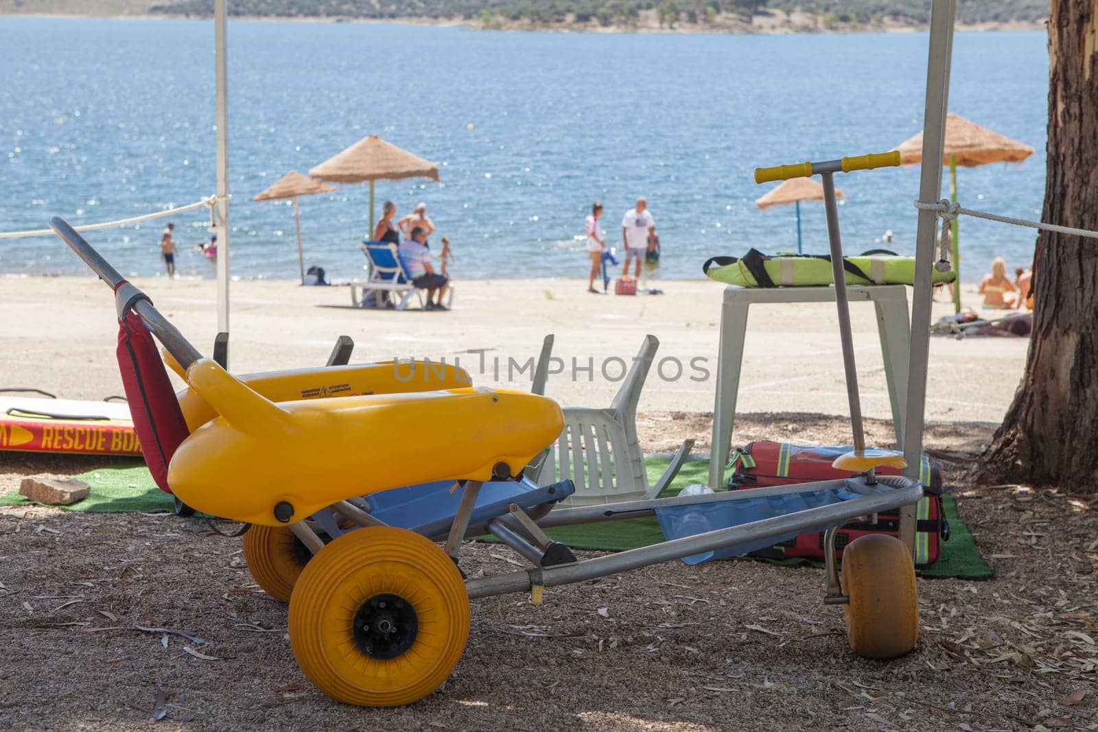 Beach wheelchair near reservoir shore ready to use. Accessible tourism concept
