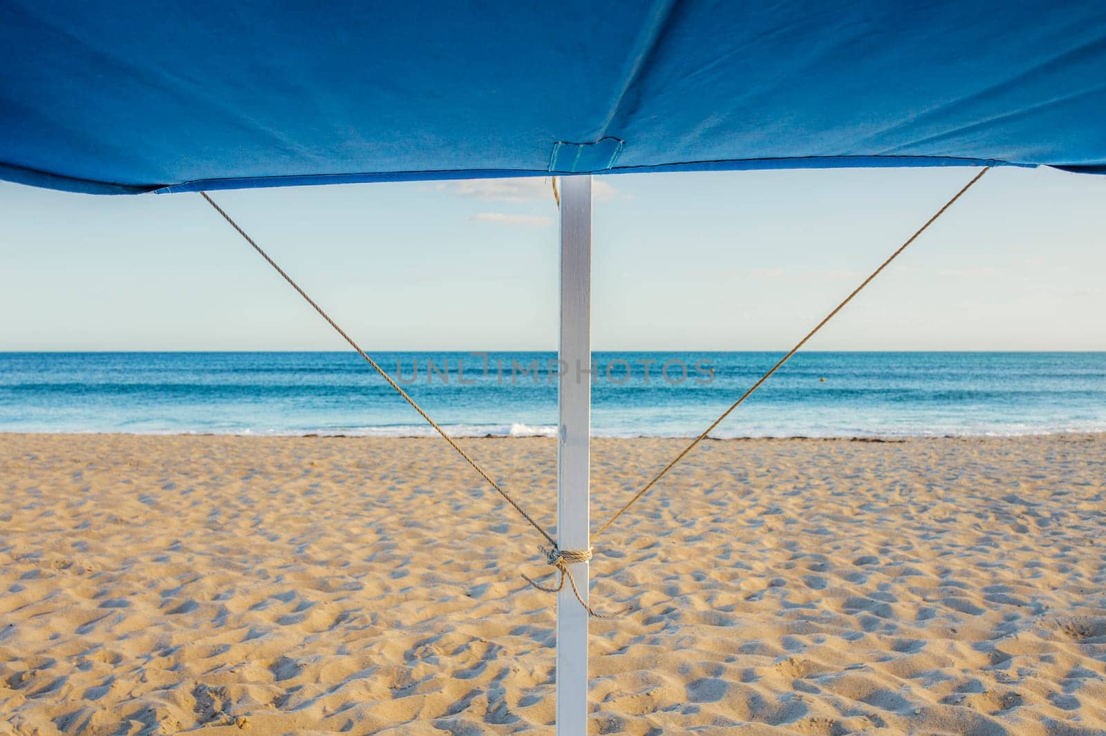 Awning structure with ocean as background. Beach trendy furniture concept