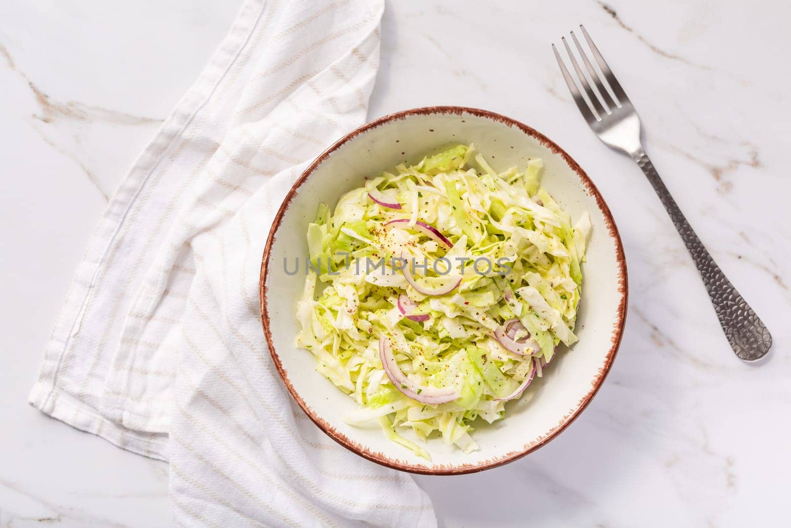 Vegan coleslaw salad made of freshly shredded white cabbage with red onions