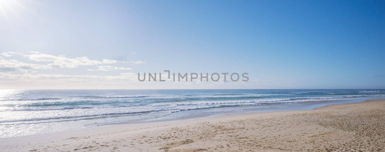 Soft pastel morning colors seascape as sun rises over ocean. Concept background for summer vacation or business travel. Inspirational beautiful relaxing scenery of seashore. Empty beach seascape with copy space.