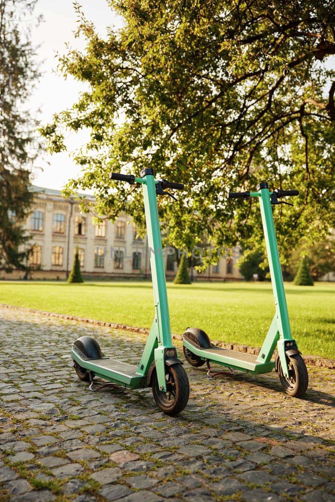 Eco-friendly electric scooter vehicles parked at university campus. Ecological transport for commuting, active recreation and healthy lifestyle