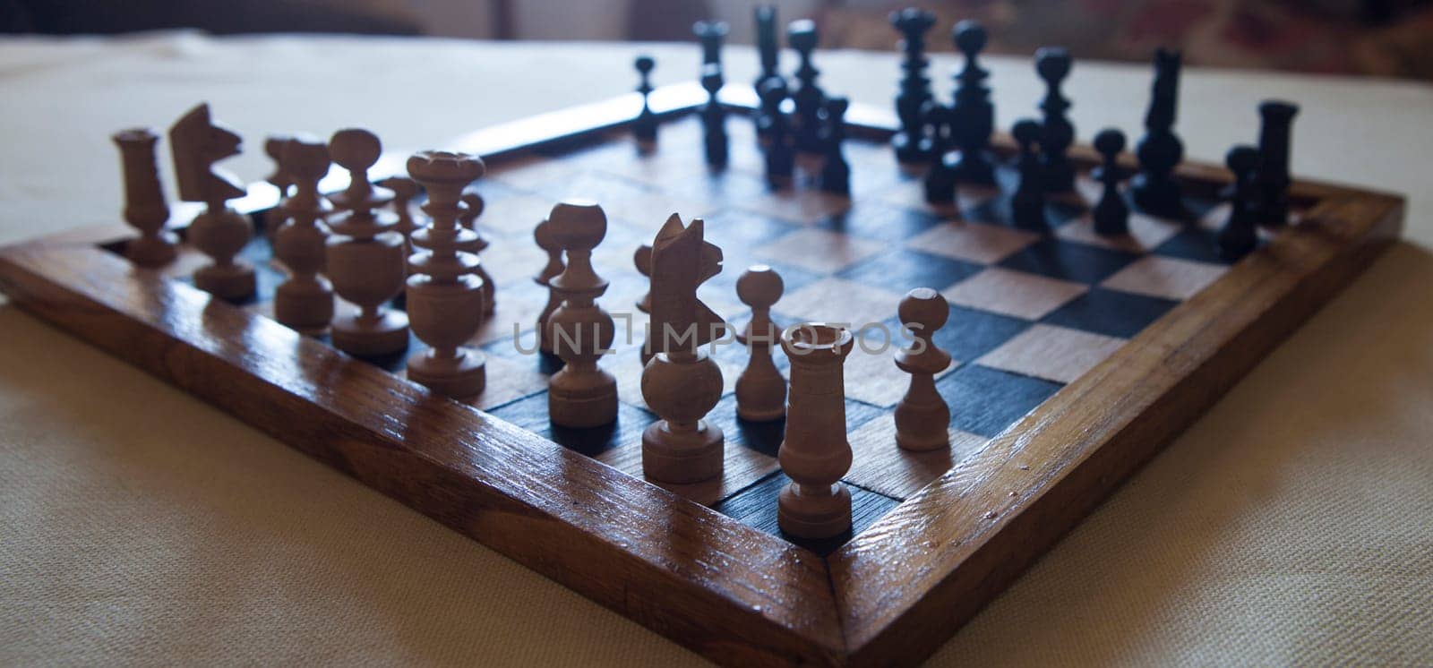 Wood turned chess board seen against the light. Cottage living room background