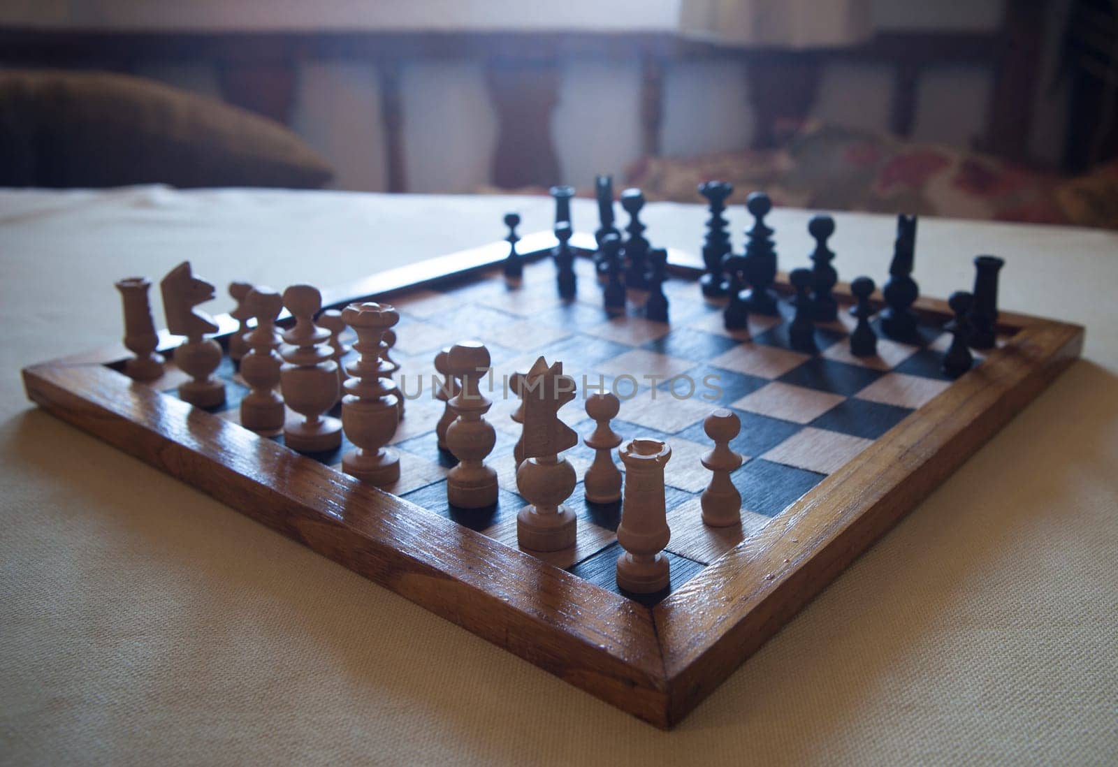 Wood turned chess board seen against the light. Cottage living room background