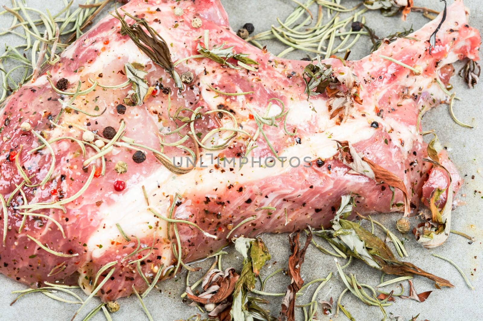 Raw pork steak Tomahawk marinated in spicy herbs on wooden background.
