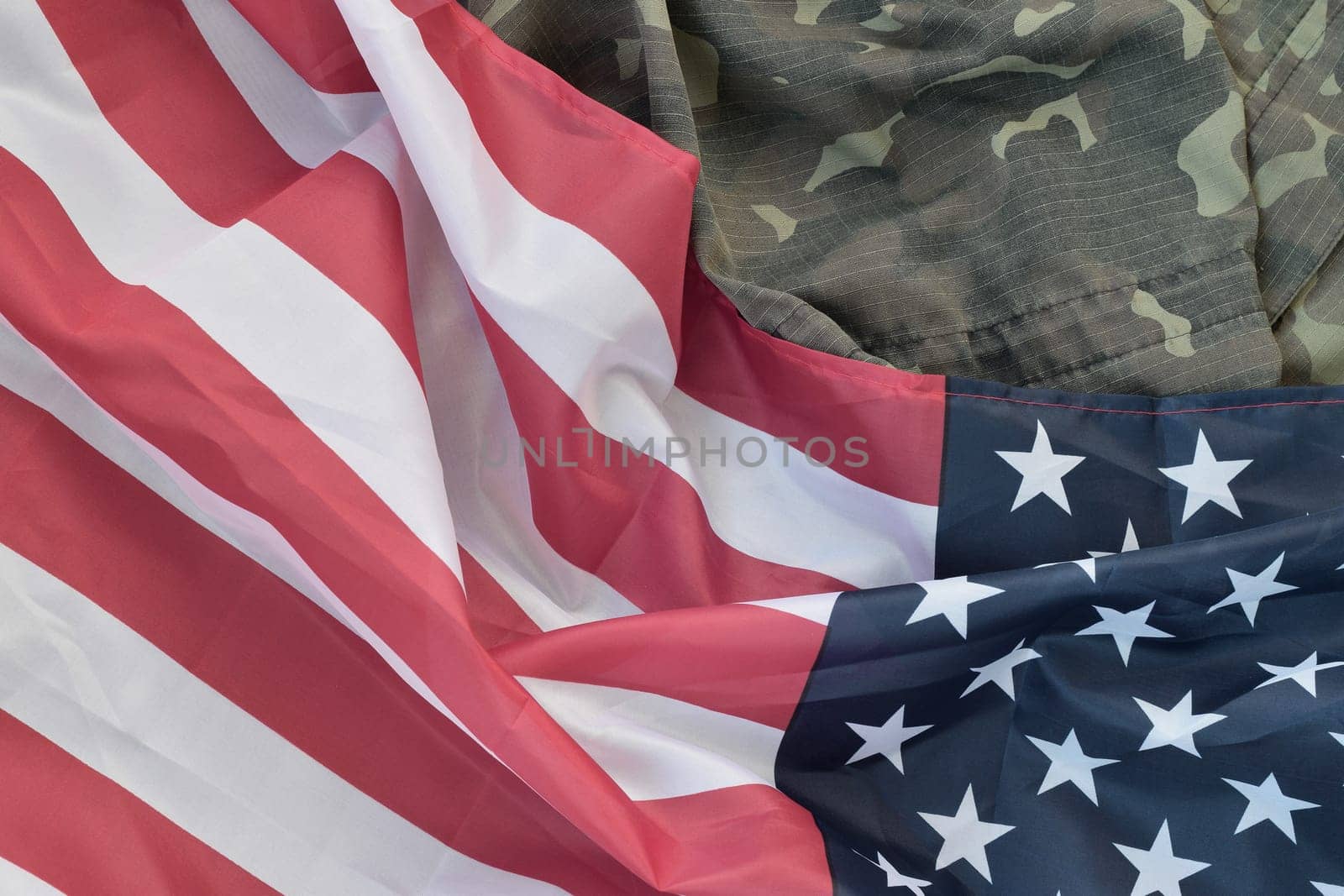 United States of America flag and folded military uniform jacket. Military symbols conceptual background banner for american patriotic holidays design