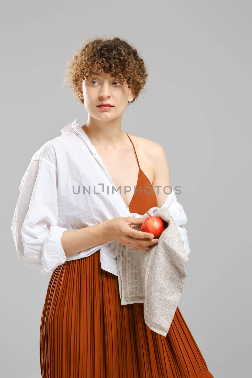 woman wiping an apple with a towel. Concept of healthy eating.