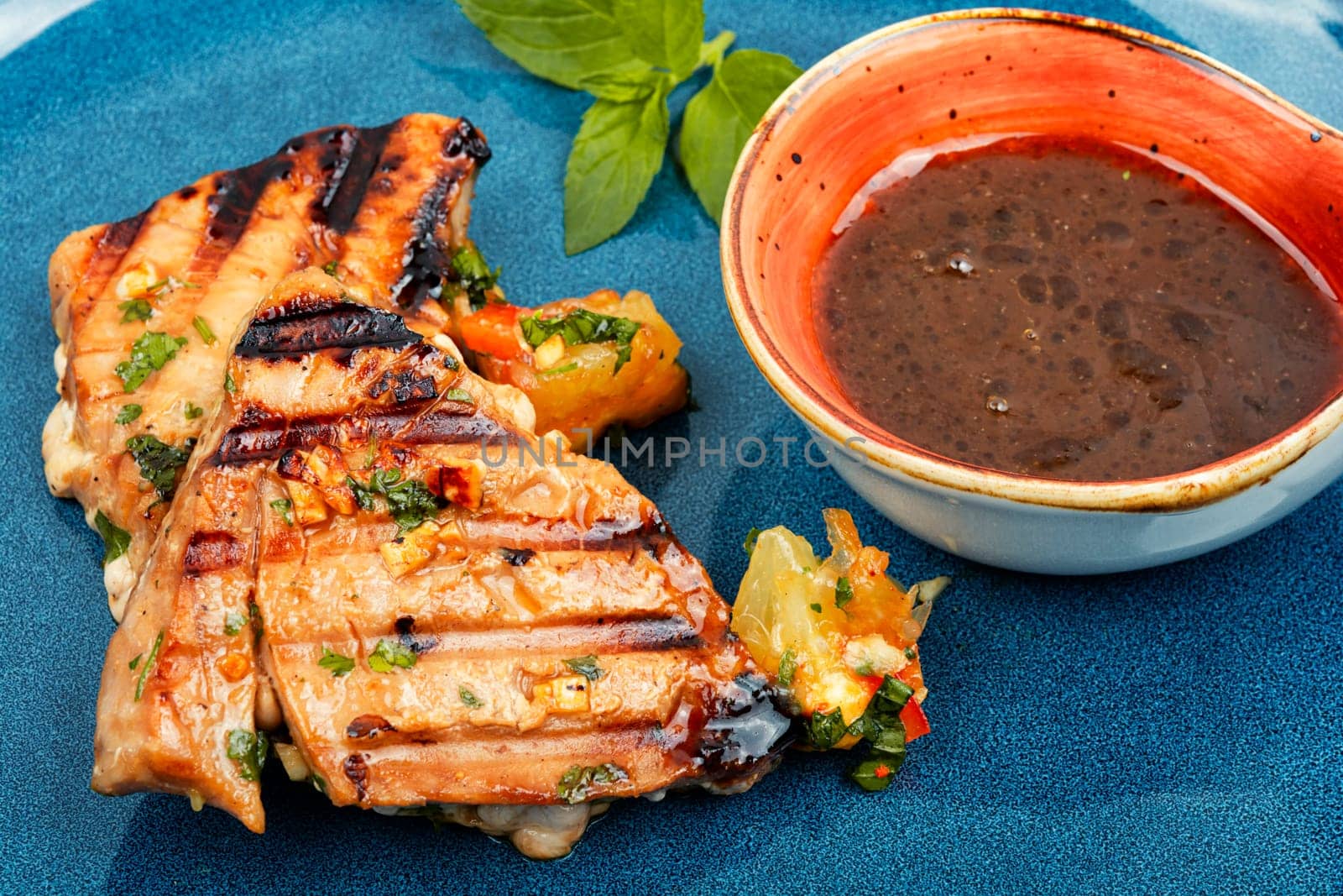 Cooked tuna steak with vegetables on a plate. Seafood.