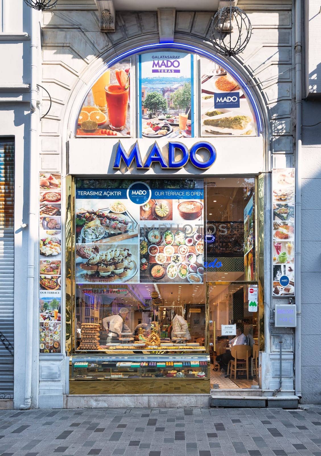 Istanbul, Turkey - May 13, 2023: Storefront of Mado Cafe in Istiklal street, with a variety of food on display in the window. The cafe is known for delicious Turkish cuisine, including Turkish delight