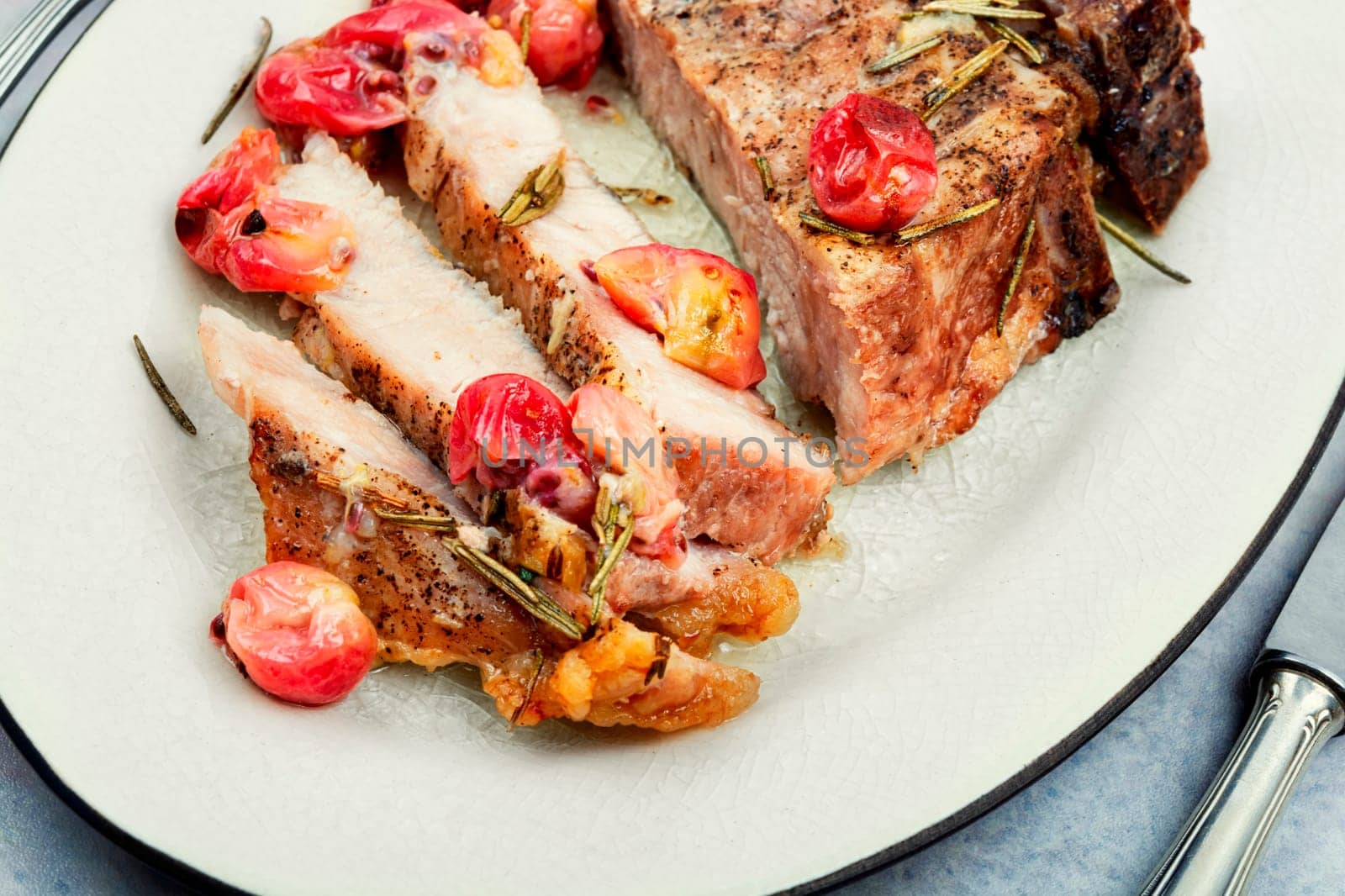 Delicious grilled beef steak with gooseberry on rustic wooden table.