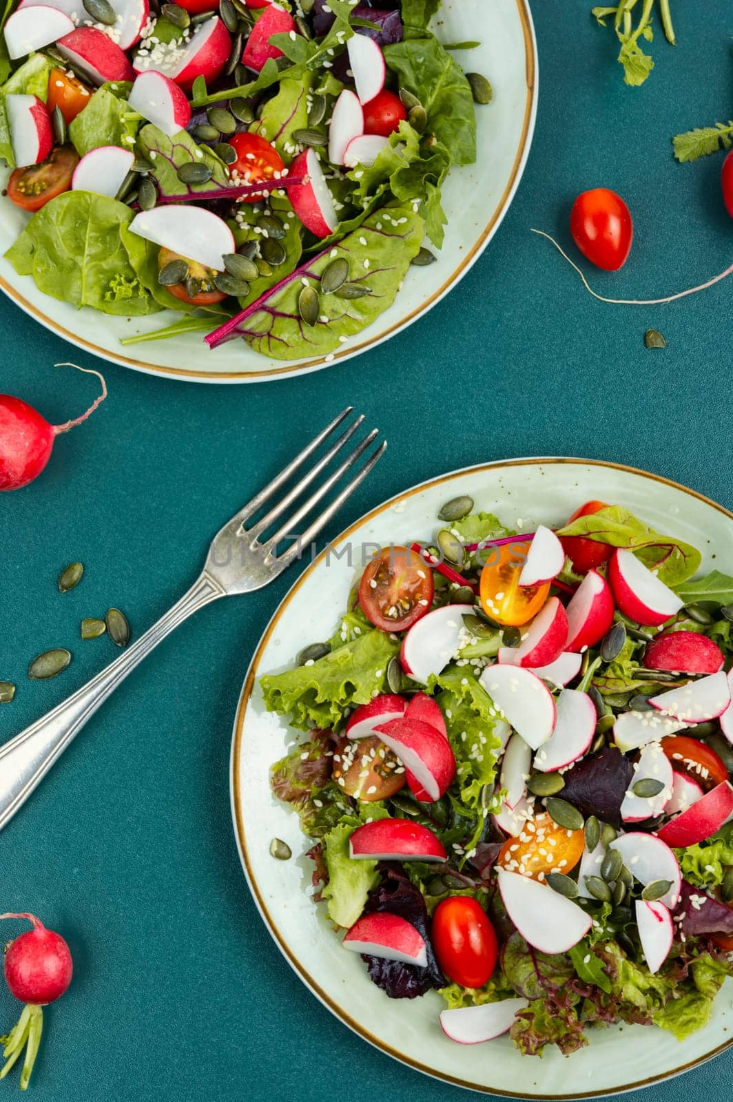 Tasty salad with radish, greens, tomato and sesame. Vegan recipe.