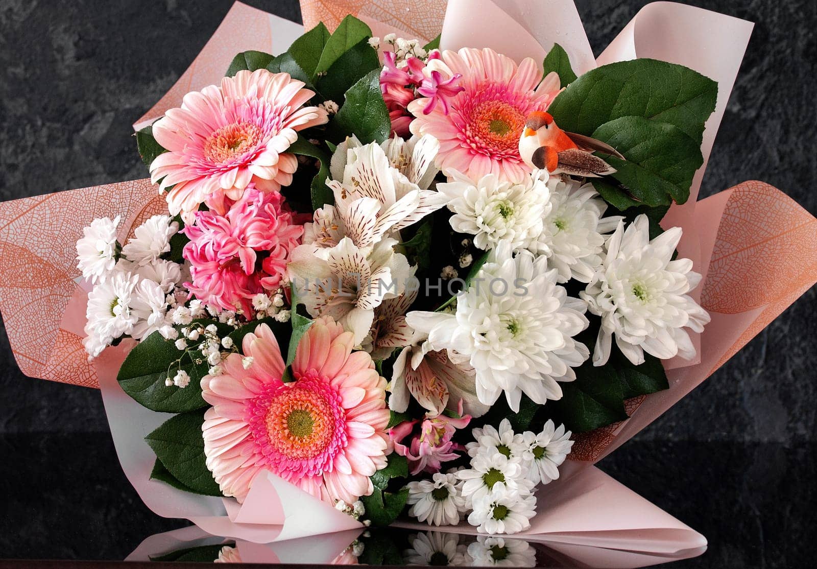 Bouquet of different flowers in pink and white tones on a dark background