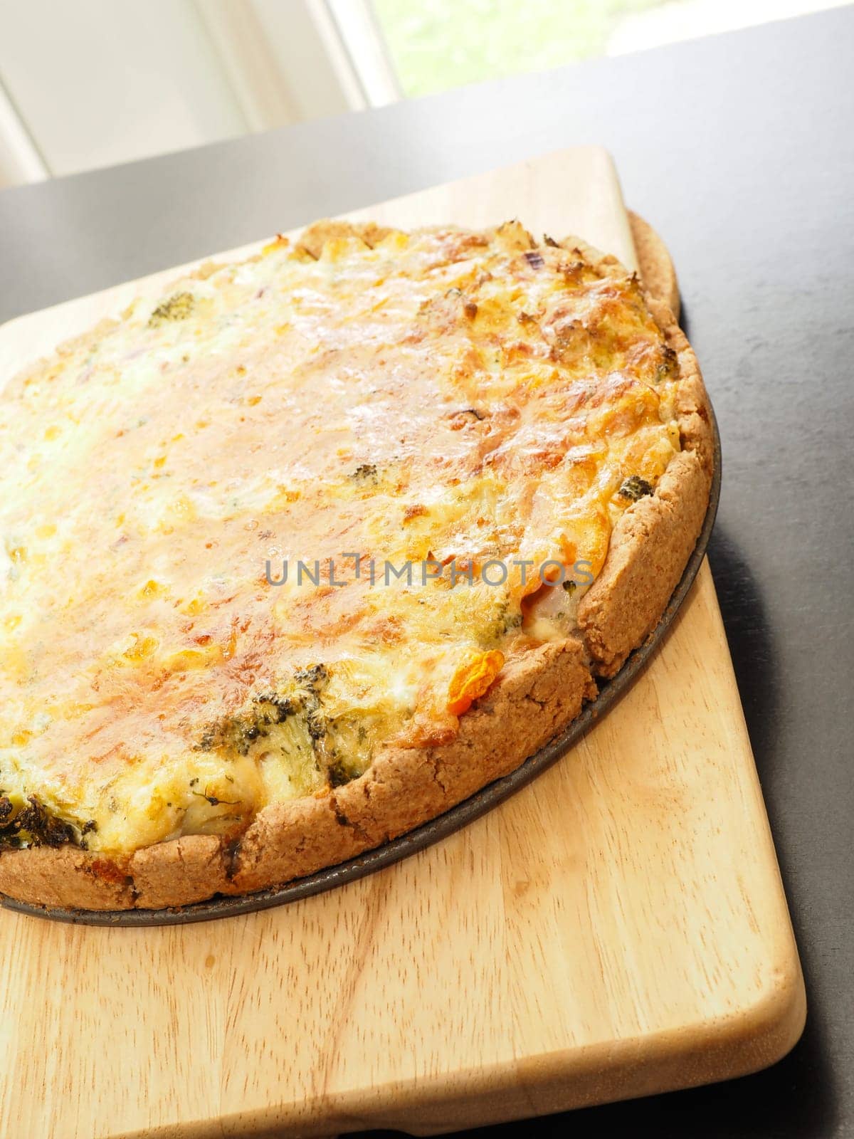 Tasty organic vegetable quiche on a cutting board in a kitchen, healthy eating or diet concept, vegetarian food