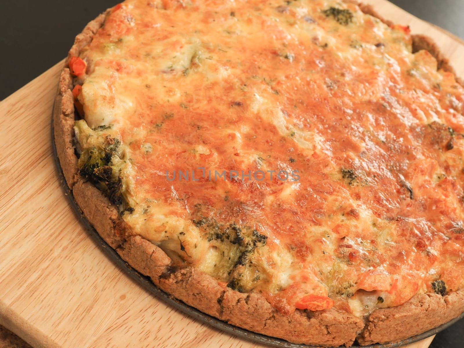 Tasty organic vegetable quiche on a cutting board in a kitchen, healthy eating or diet concept, vegetarian food