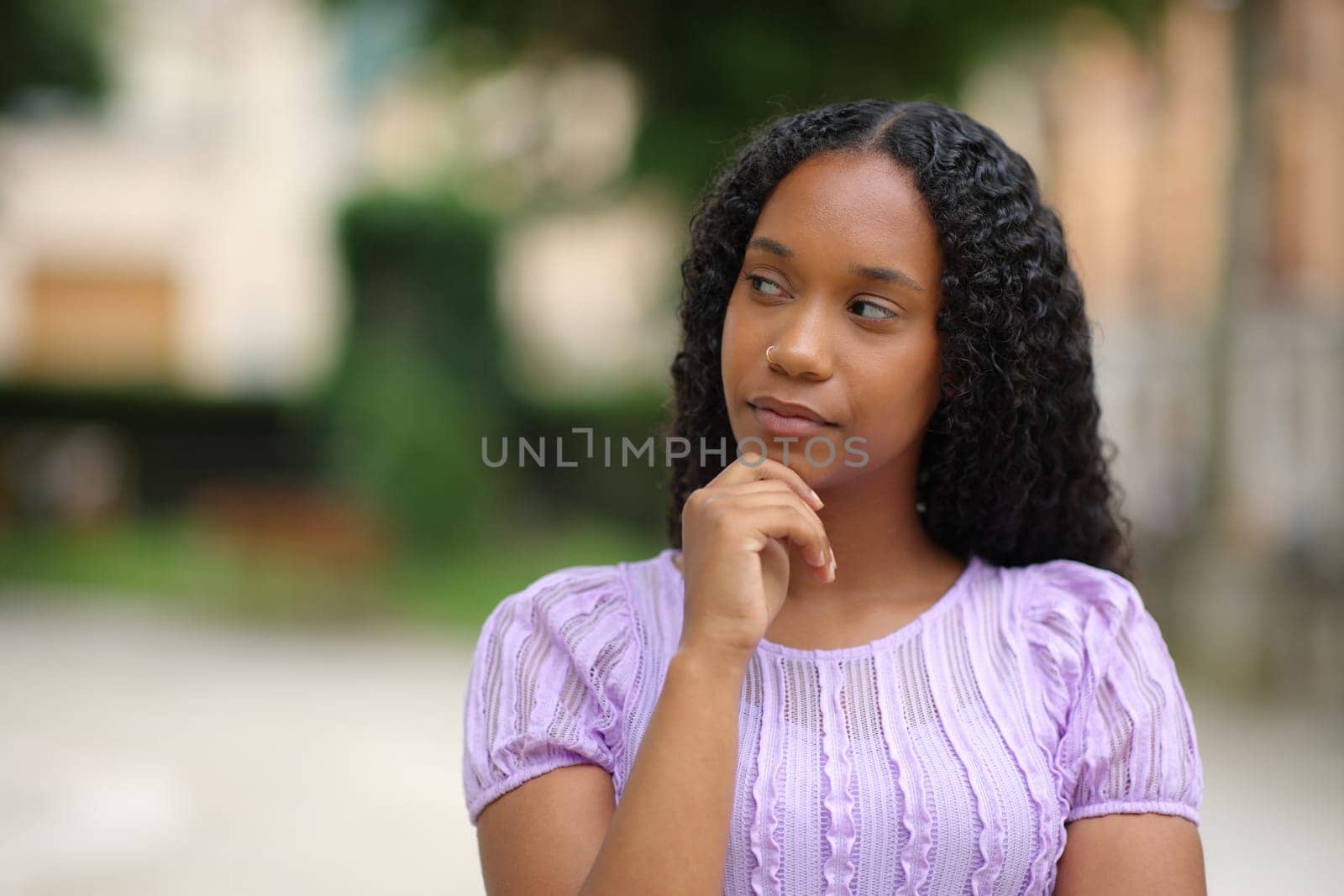 Pensive black woman wondering looking at side in the street