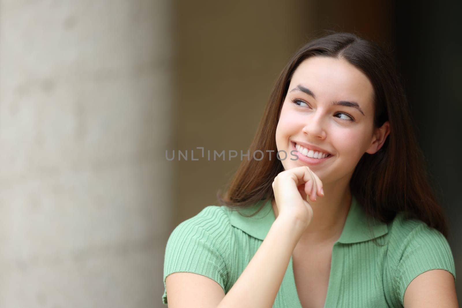 Happy woman in the street thinking looking at side