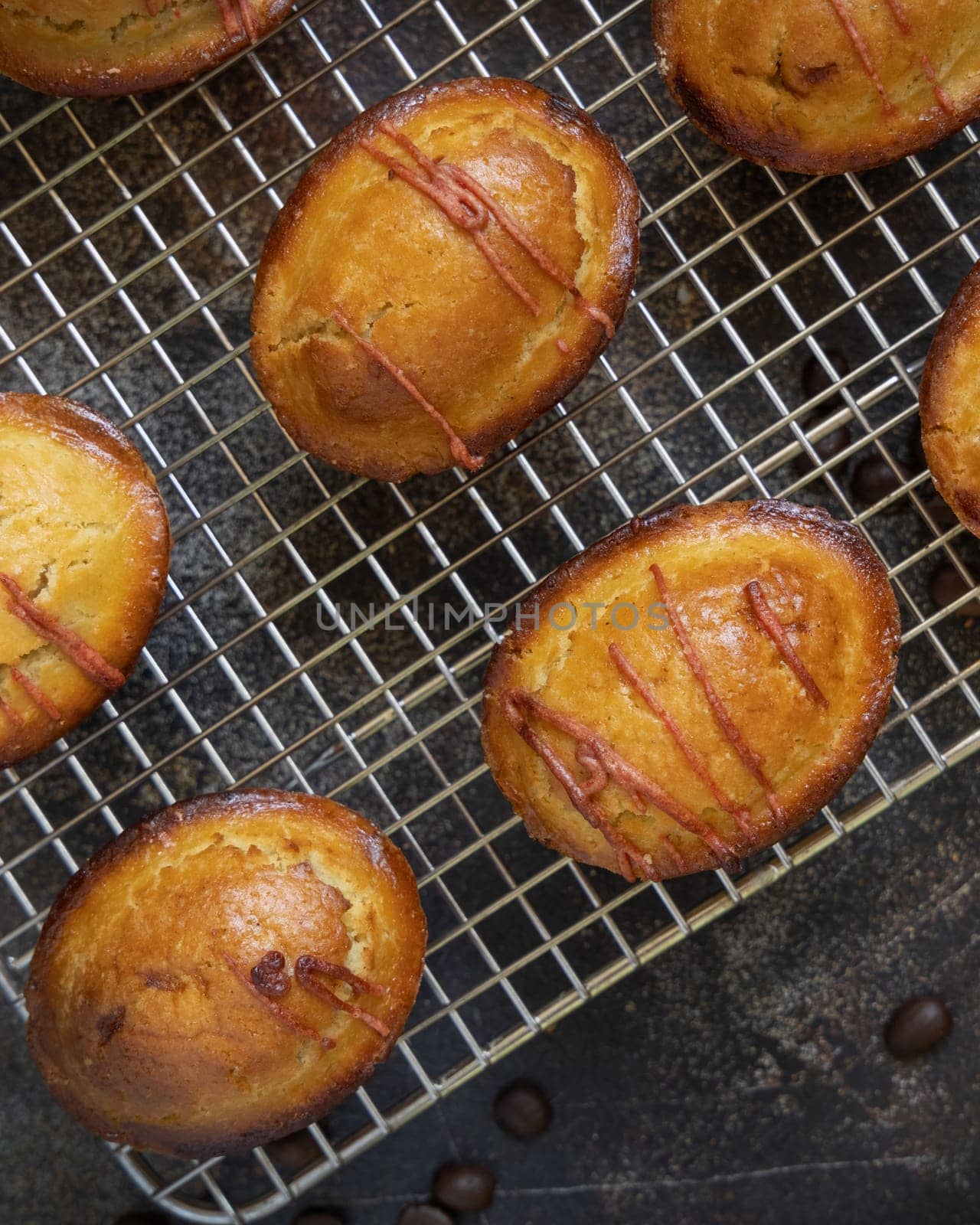 Pasticciotto leccese pastry filled with egg custard cream and sour cherry jam, on a cooling backing rack on a dark table, copy space, top view. Typical apulian breakfast