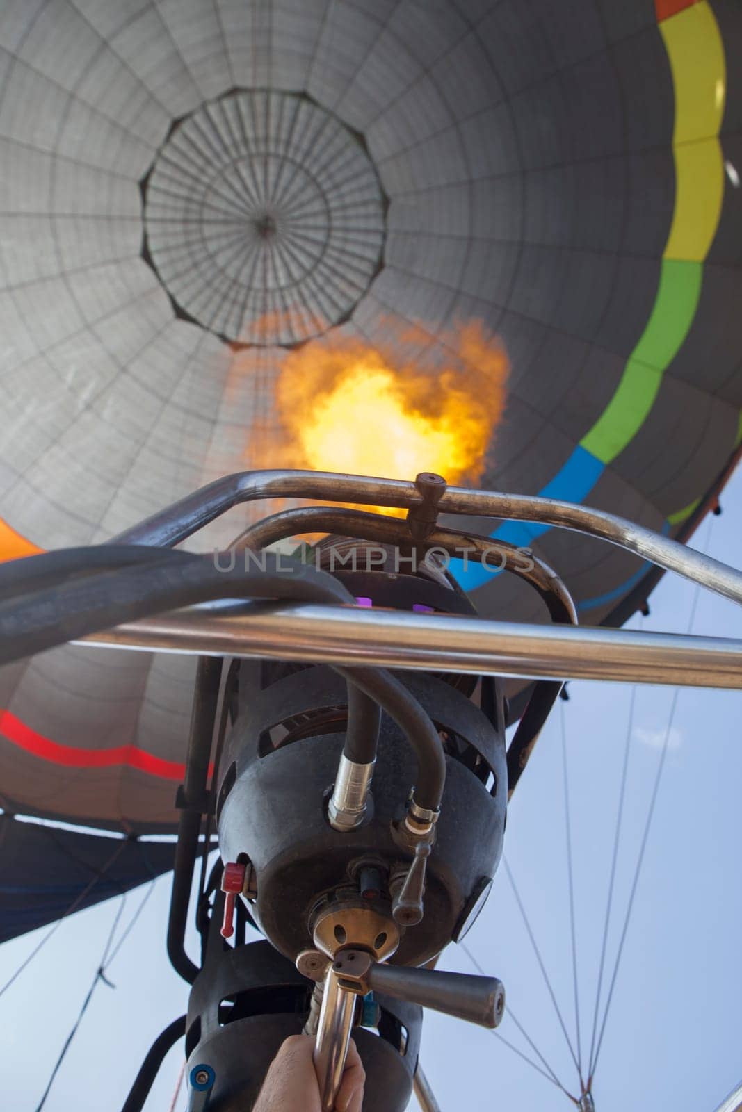 Hot air balloon pilot operating the burners. Low angle inside view