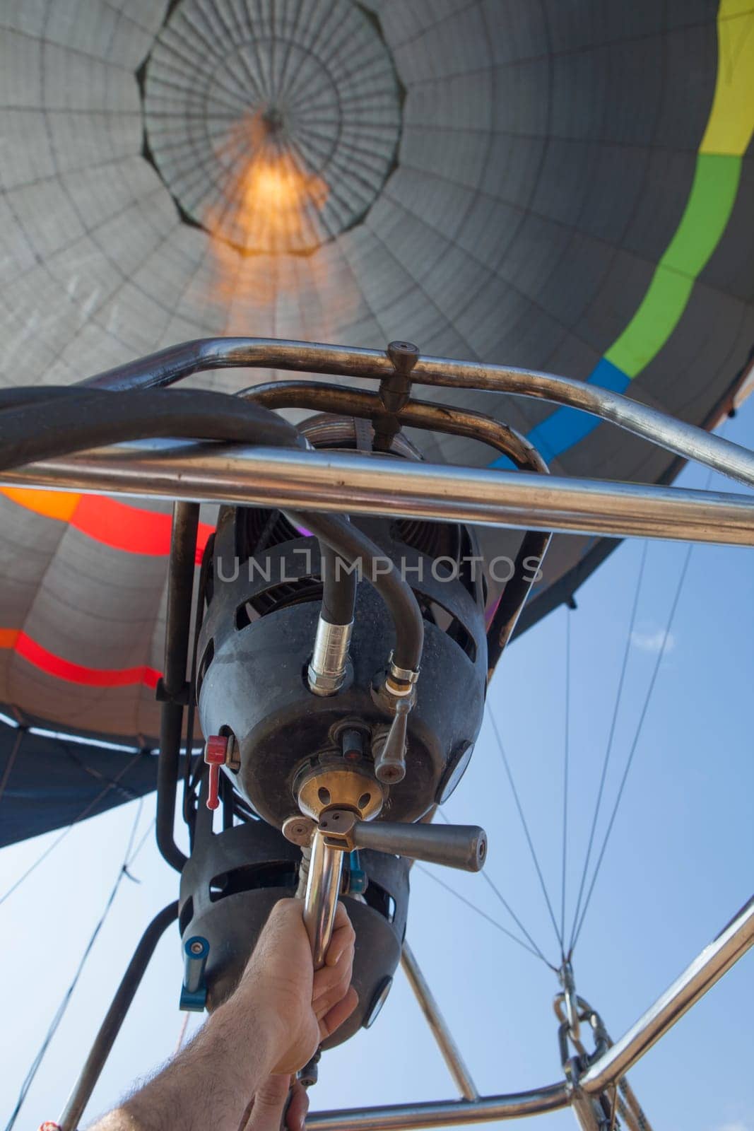 Hot air balloon pilot operating the burners. Low angle inside view