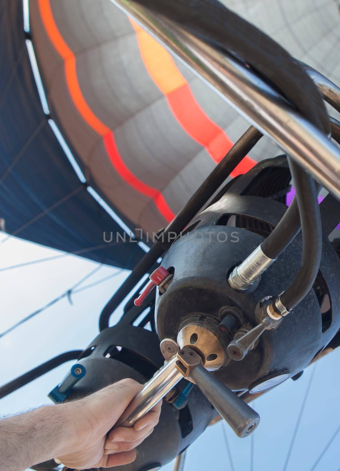 Hot air balloon pilot operating the burners. Low angle inside view