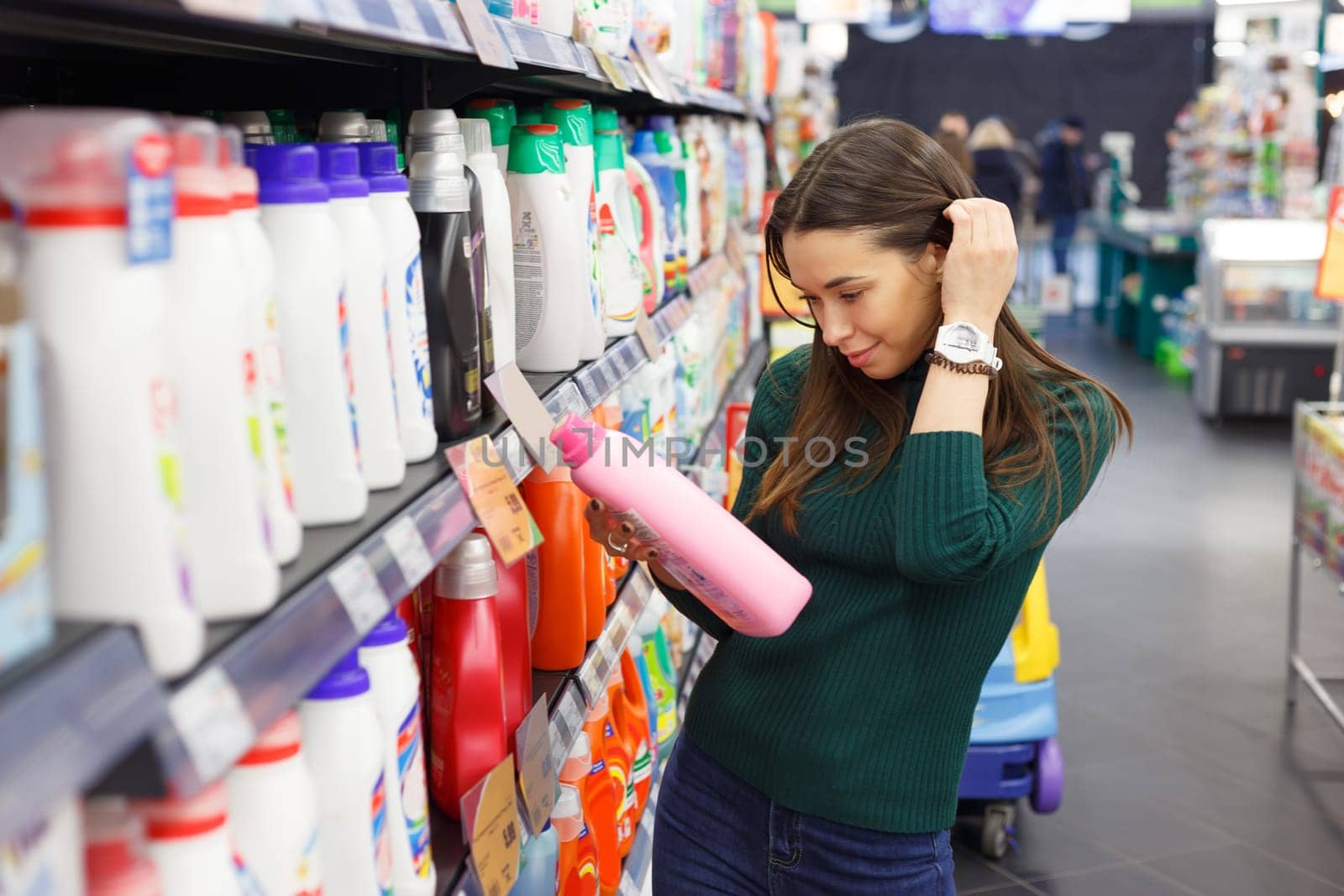 Woman choosing laundry detergent in grocery store