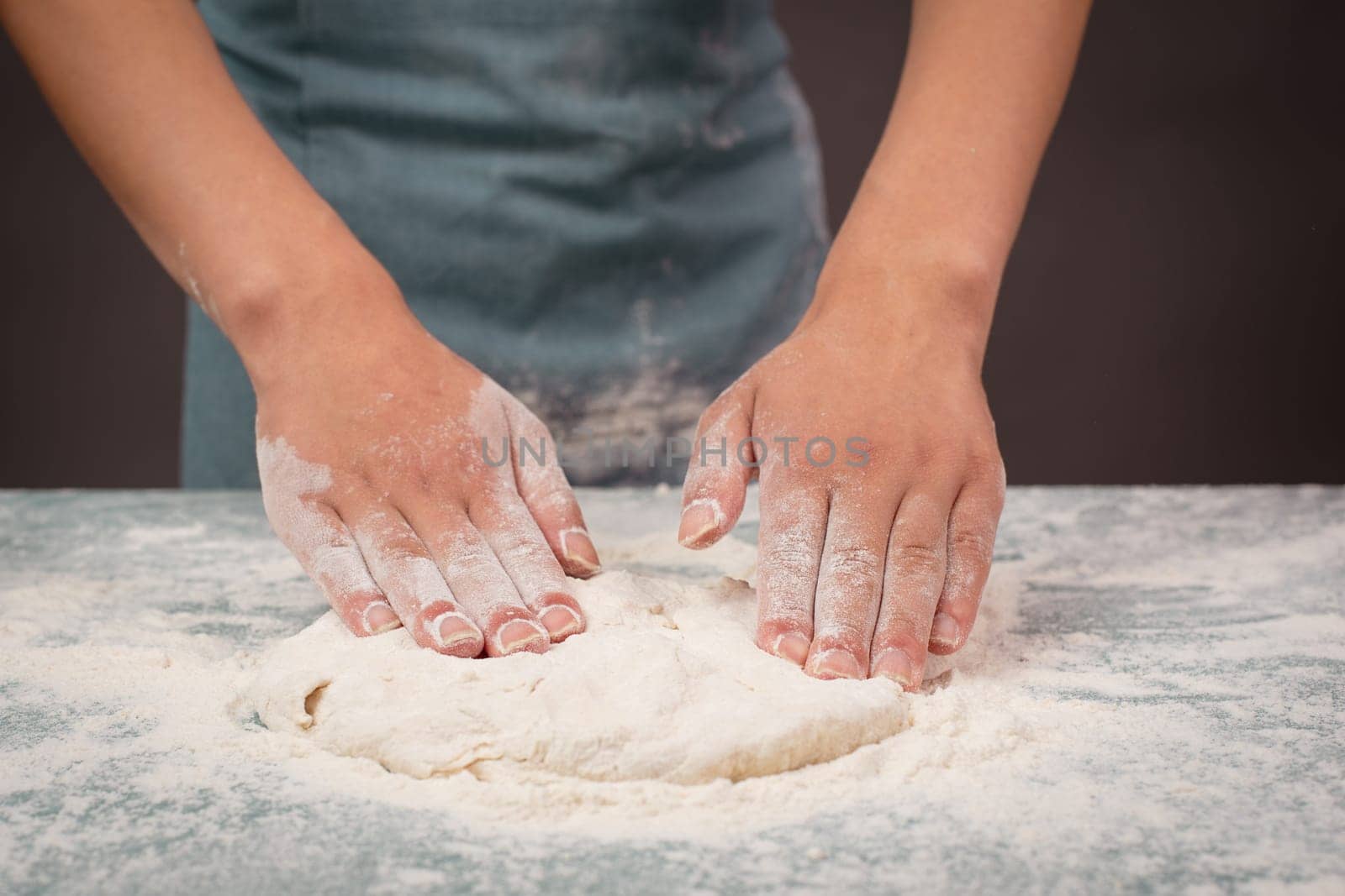 Baker kneading dough for artisan bread or pizza with his hands, prepare ingredients for food, baking pastry