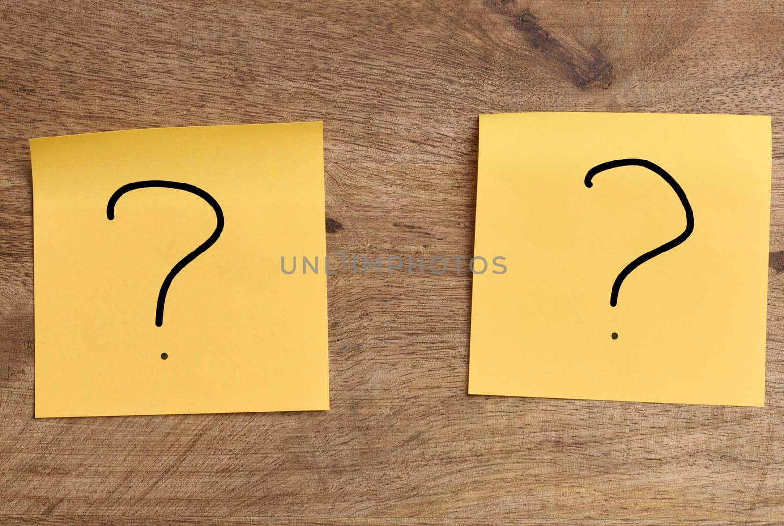 Orange stickers with a question mark on a wooden board