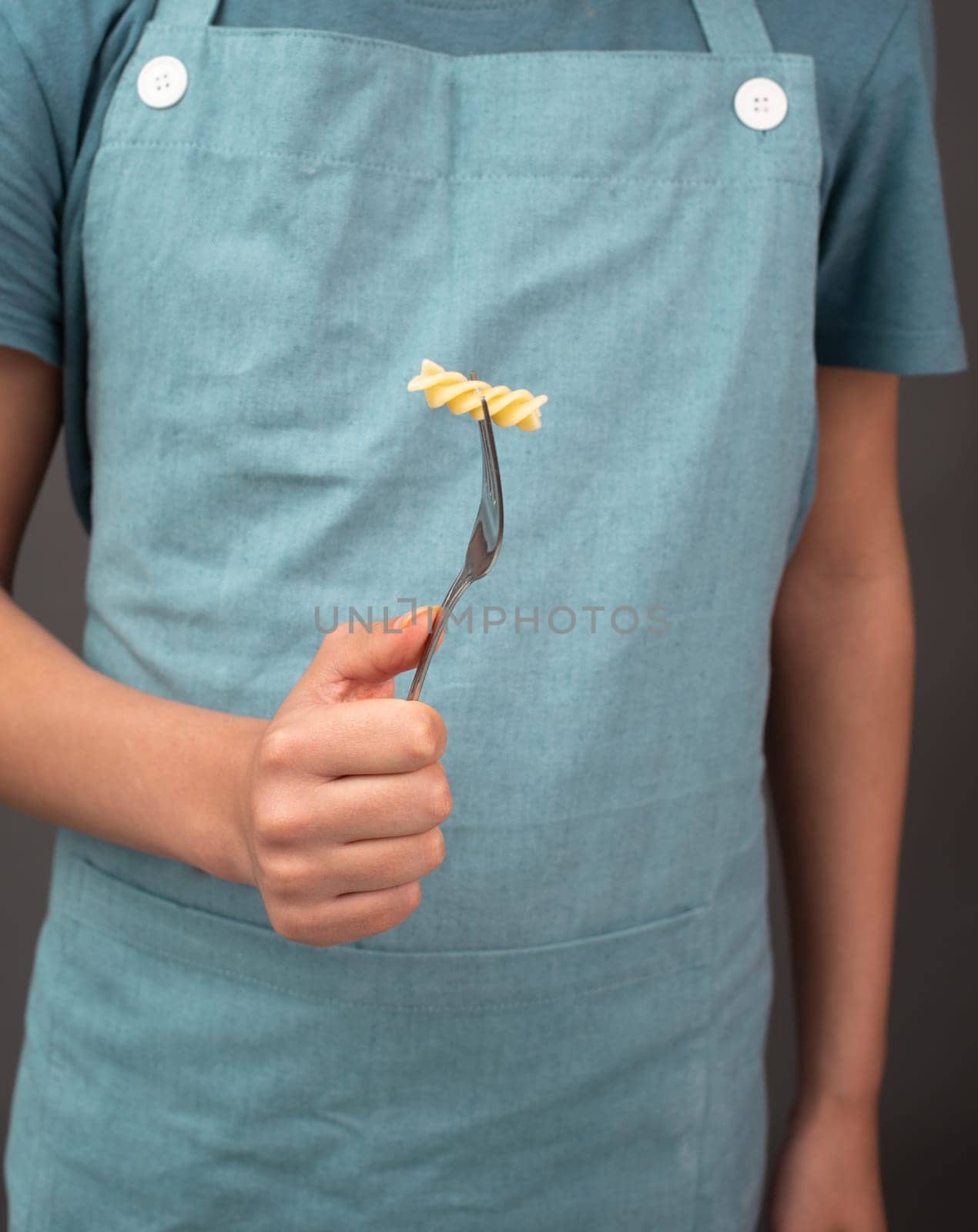 Cooked fusilli pasta on a fork, italian food ingredients, preparing dinner