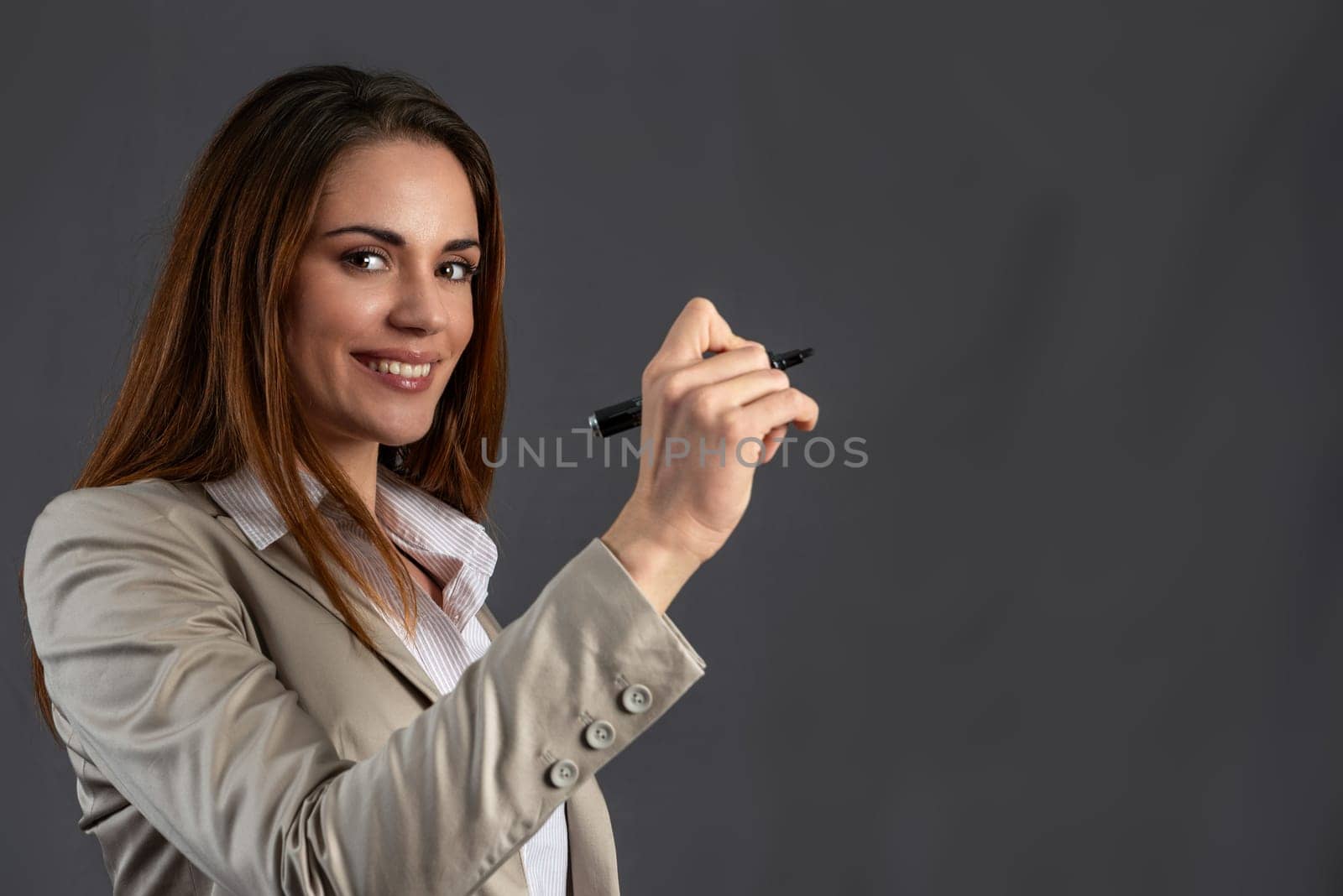 Beautiful business woman is writing a note withe a marker on a window