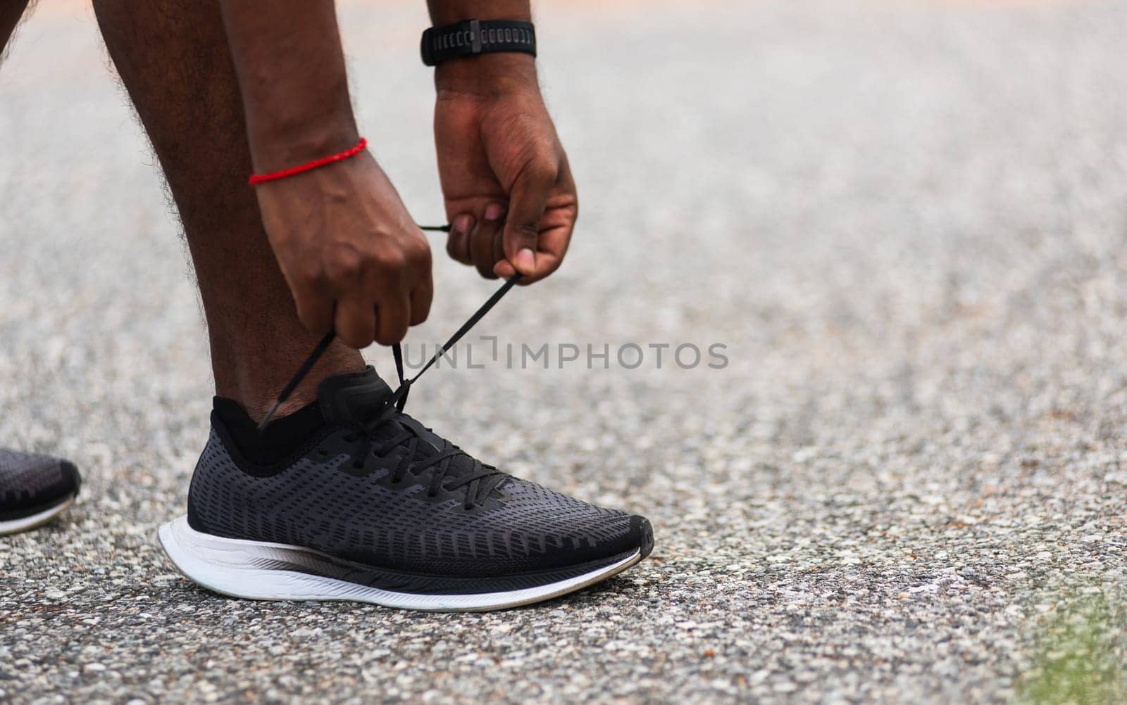 Close up Asian sport runner black man standing he trying shoelace running shoes getting ready for jogging and run at the outdoor street health park, healthy exercise workout concept