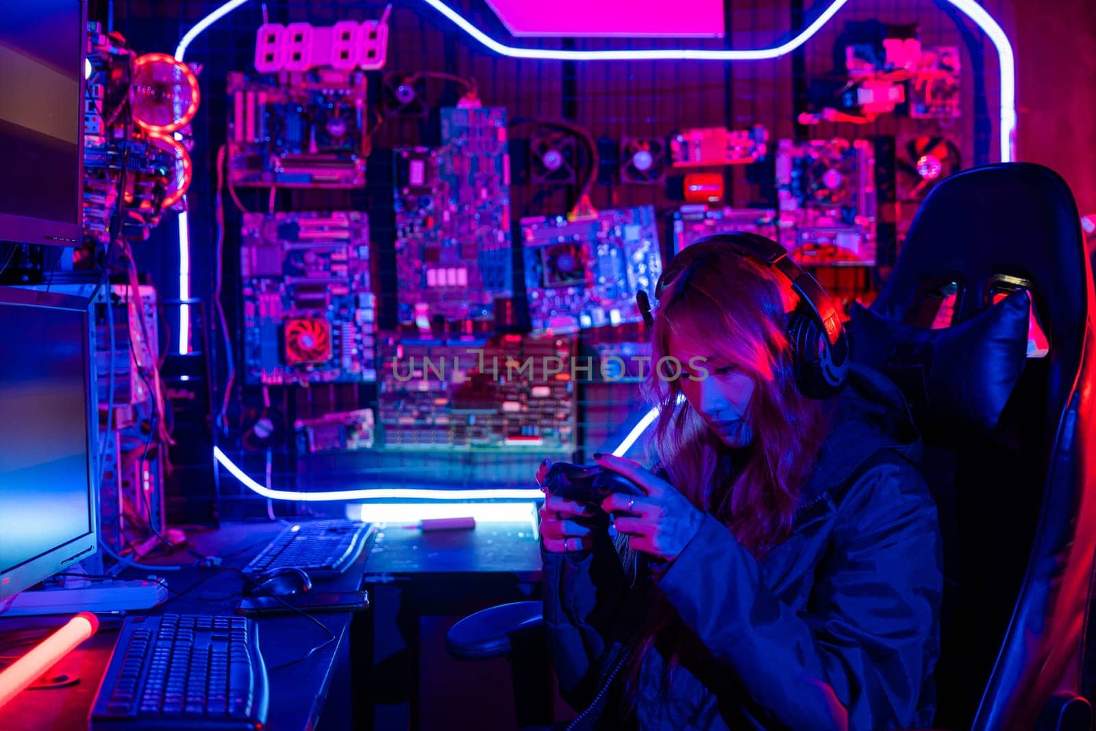 Gamer using joystick controller for virtual tournament plays online video game with computer neon lights, woman wear gaming headphones playing live stream esports games console at home