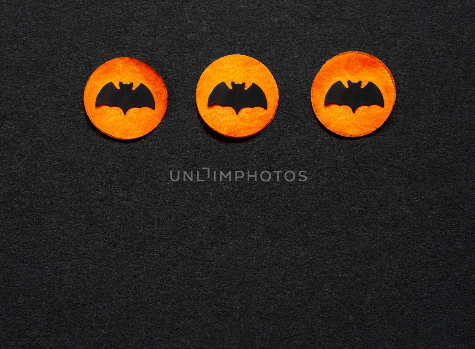 Black Halloween Background With Three Orange Dots With Bats And Copyspace
