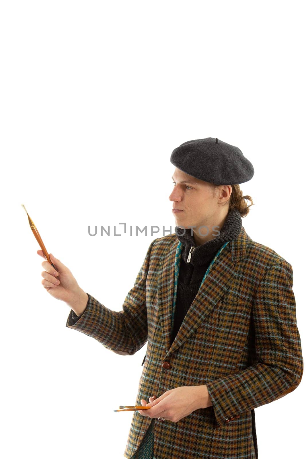 Young smiling artist with a beret on his head on a white background