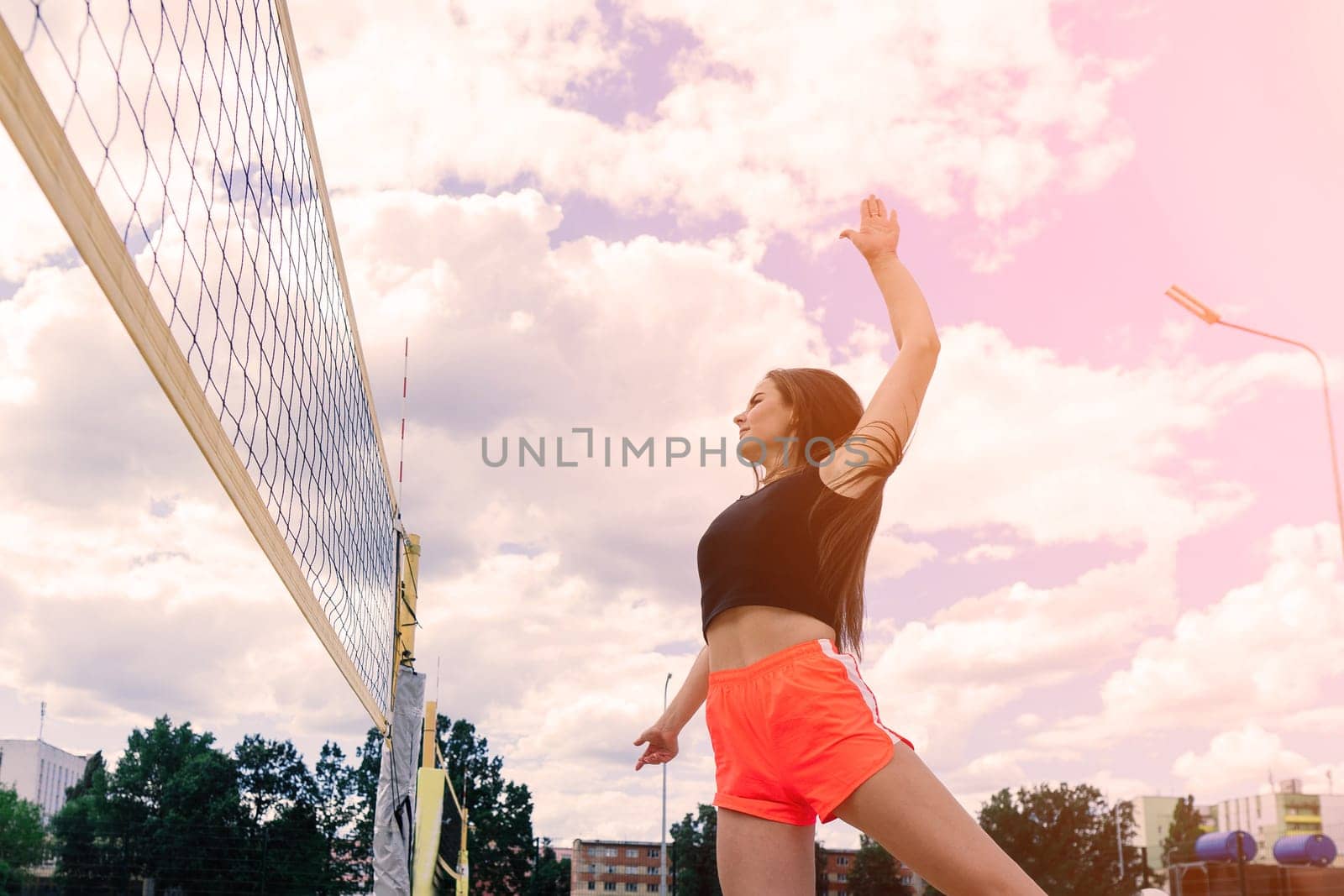 Young, beautiful girl athlete in sportswear is training and running, stretching at the stadium