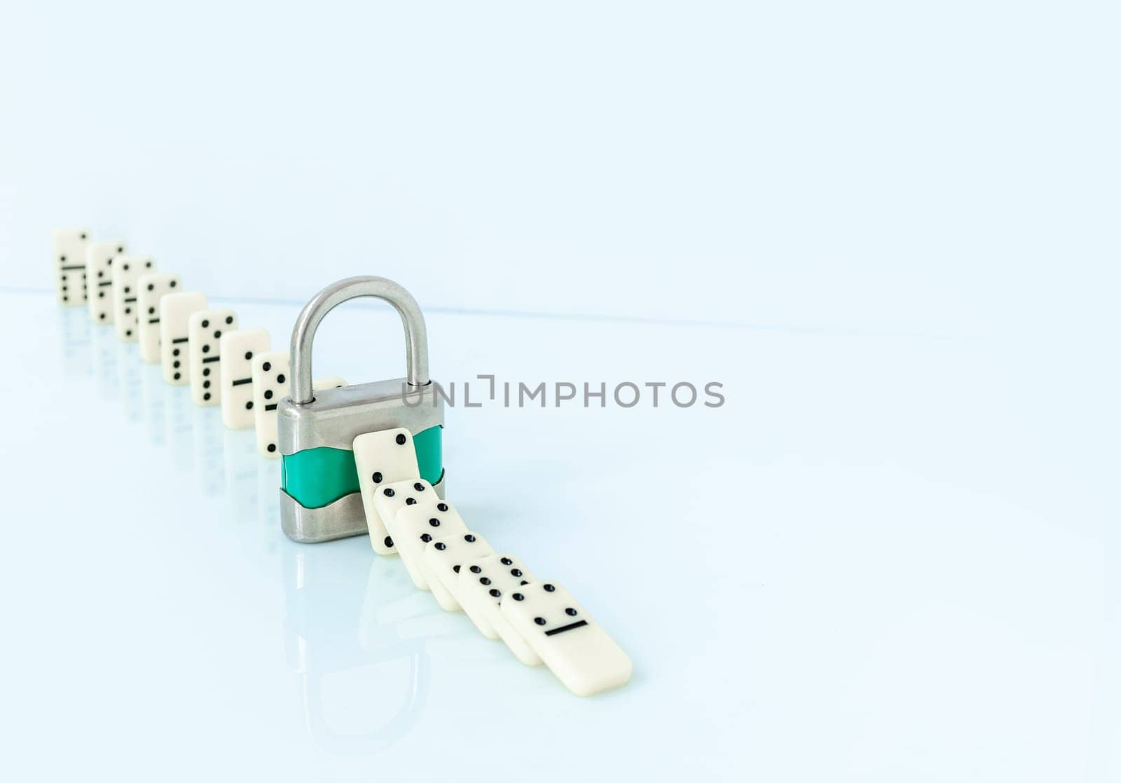 Padlock stopping domino effect falling. Safety concept..