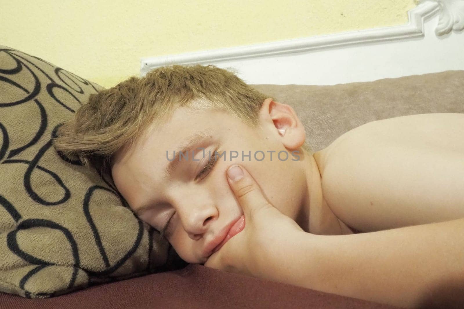 10 year old Caucasian boy fell asleep on the couch. Children's dream. Sleep problems, falling asleep, insomnia, fatigue. The concept of health, mode of wakefulness and rest, education and prevention
