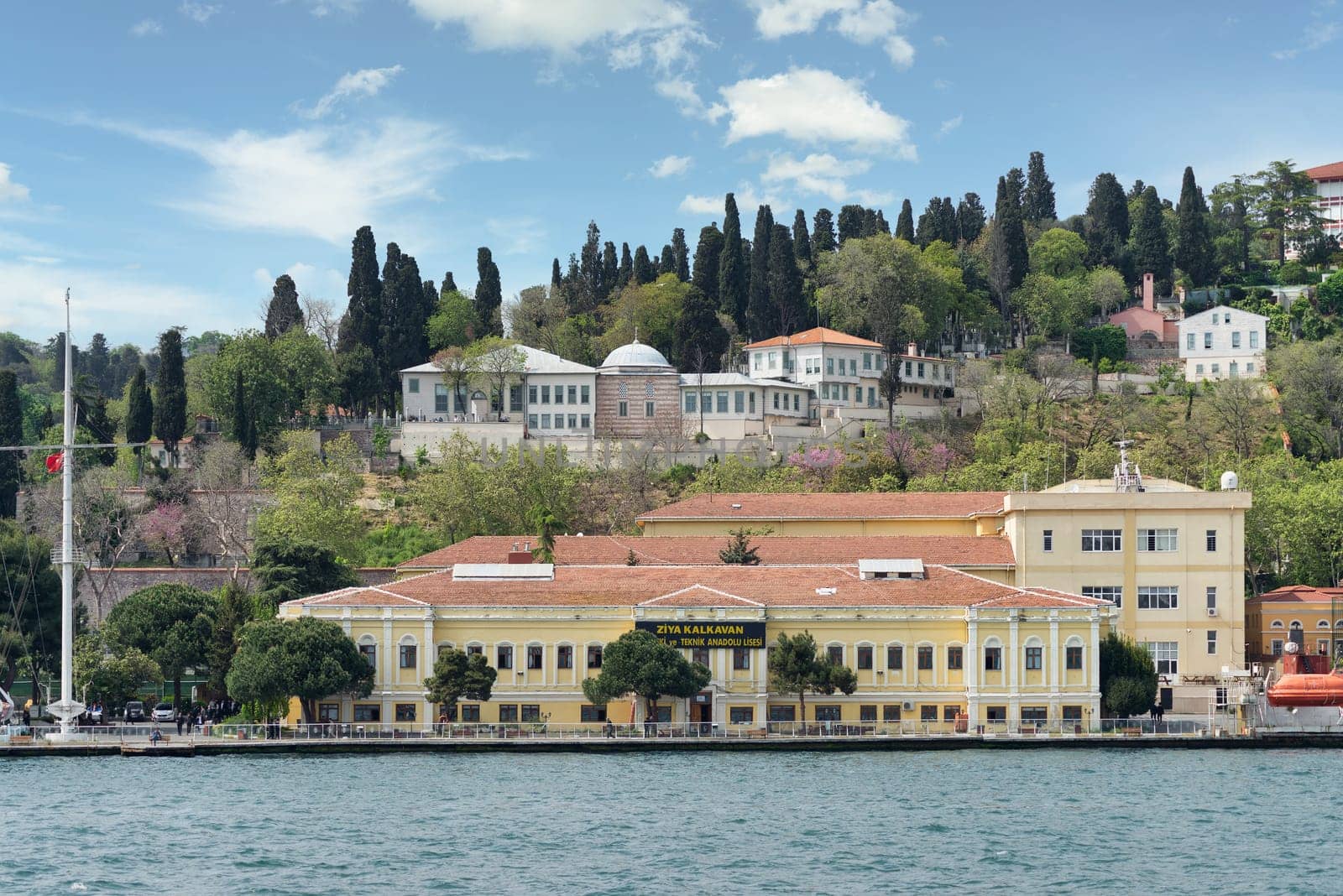 Istanbul, Turkey - May 8 2023: Ziya Kalkavan Vocational and Technical Anatolian High School in Ortakoy, Besiktas, located on the shores of the Bosphorus Strait with beautiful view of the city skyline