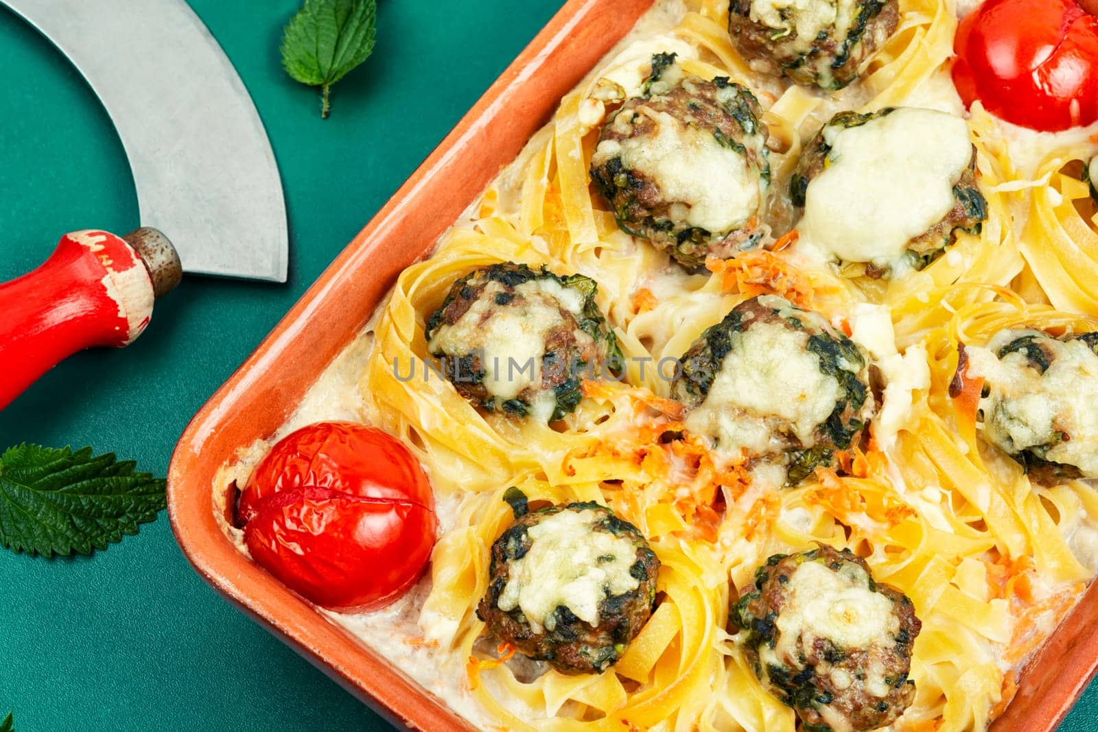 Meatballs served over appetizing noodles in baking dish. Italian food.