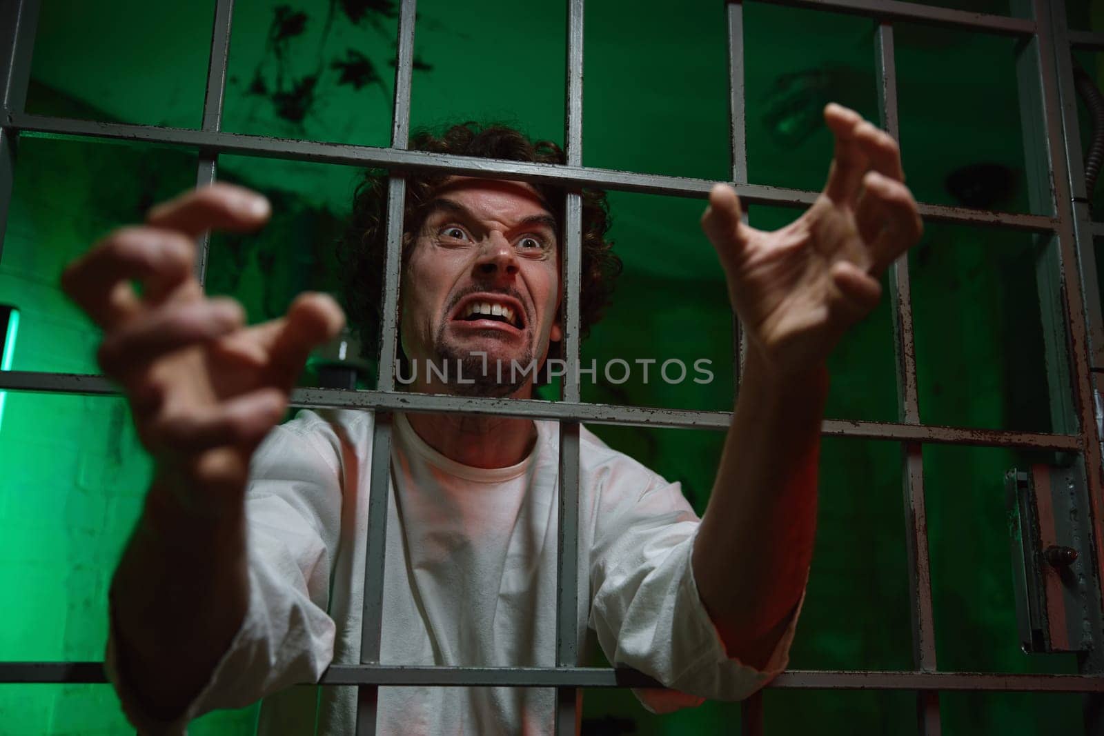 Mentally unstable male patient with attack of rabies locked in cage ward. Psychiatric department in clinic and mad people treatment