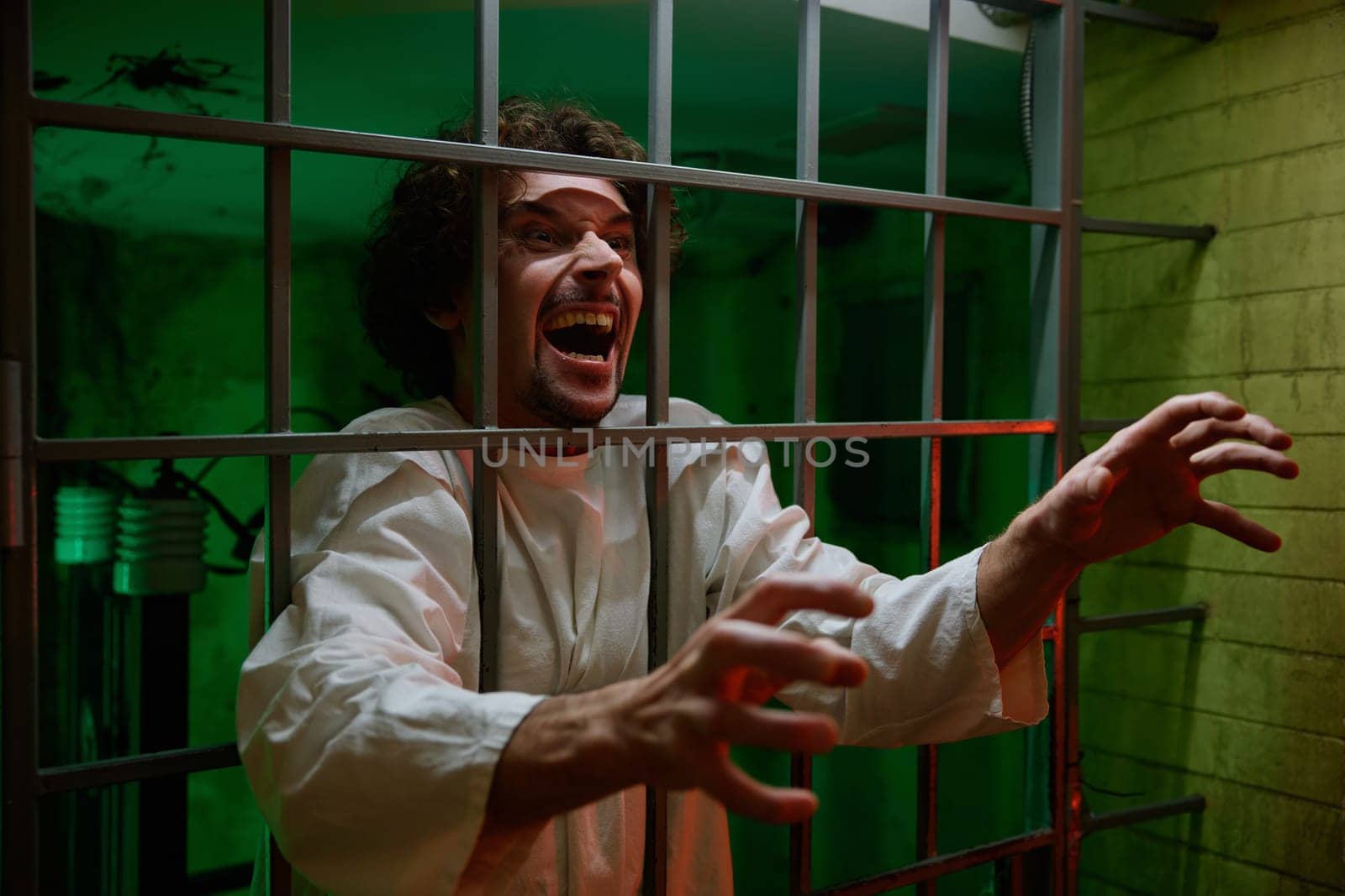 Mentally ill male patient with attack of rabies locked in cage ward. Psychiatric department in clinic and mad people treatment