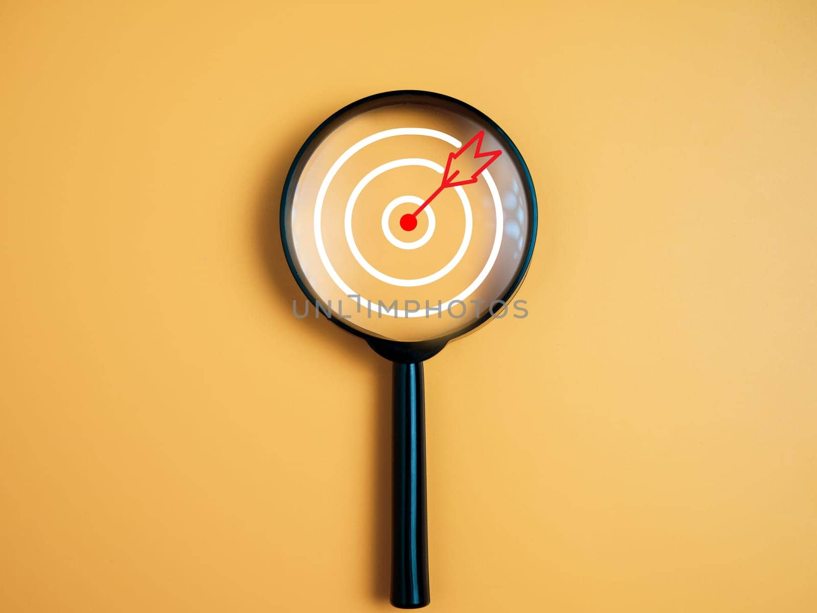 Target, objective, Goal achievement, Purposefulness concept. Magnifying glass focus on dartboard icon over yellow background.