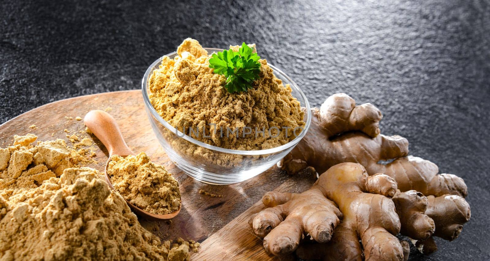 A bowl with ground ginger and its fresh rhizome.